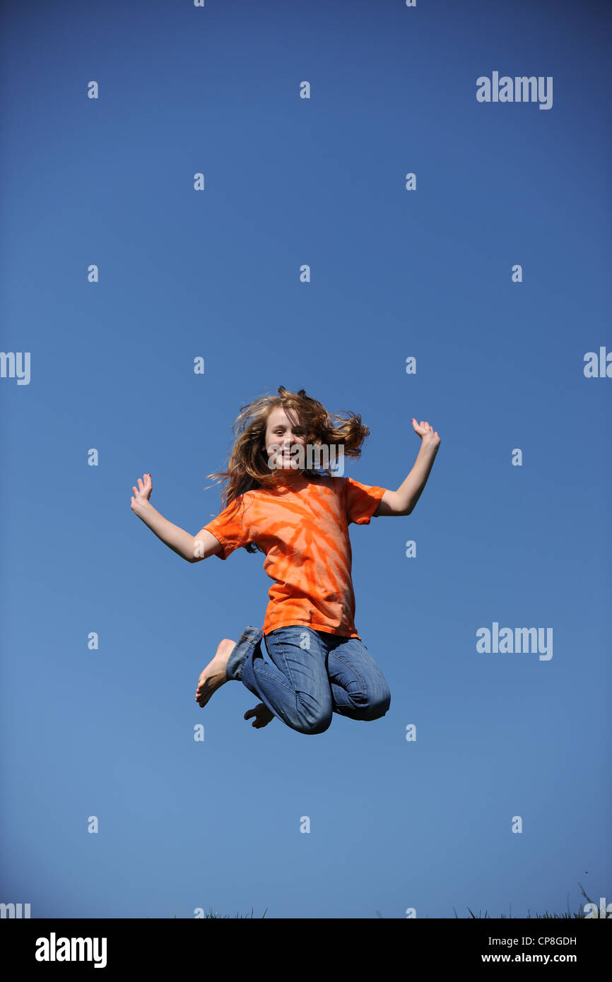 Young Girl Jumping on a sunny day against a blue sky Stock Photo - Alamy