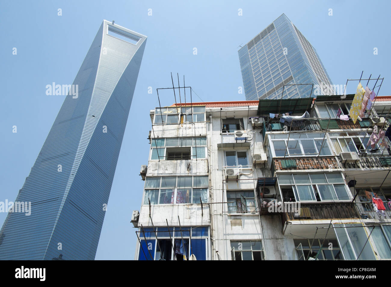 Contrast between old apartment building with modern skyscrapers to rear in Lujiazui financial district in Shanghai China Stock Photo