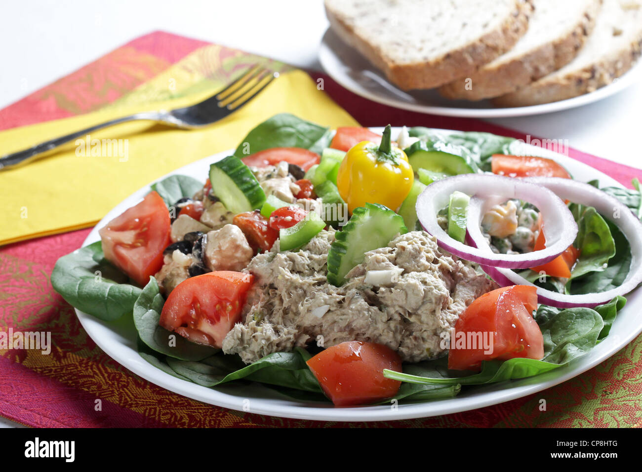 A luncheon salad plate of tuna and feta cheese salads with garnishes of tomatoes, cucumbers and onions with whole grain bread. Stock Photo