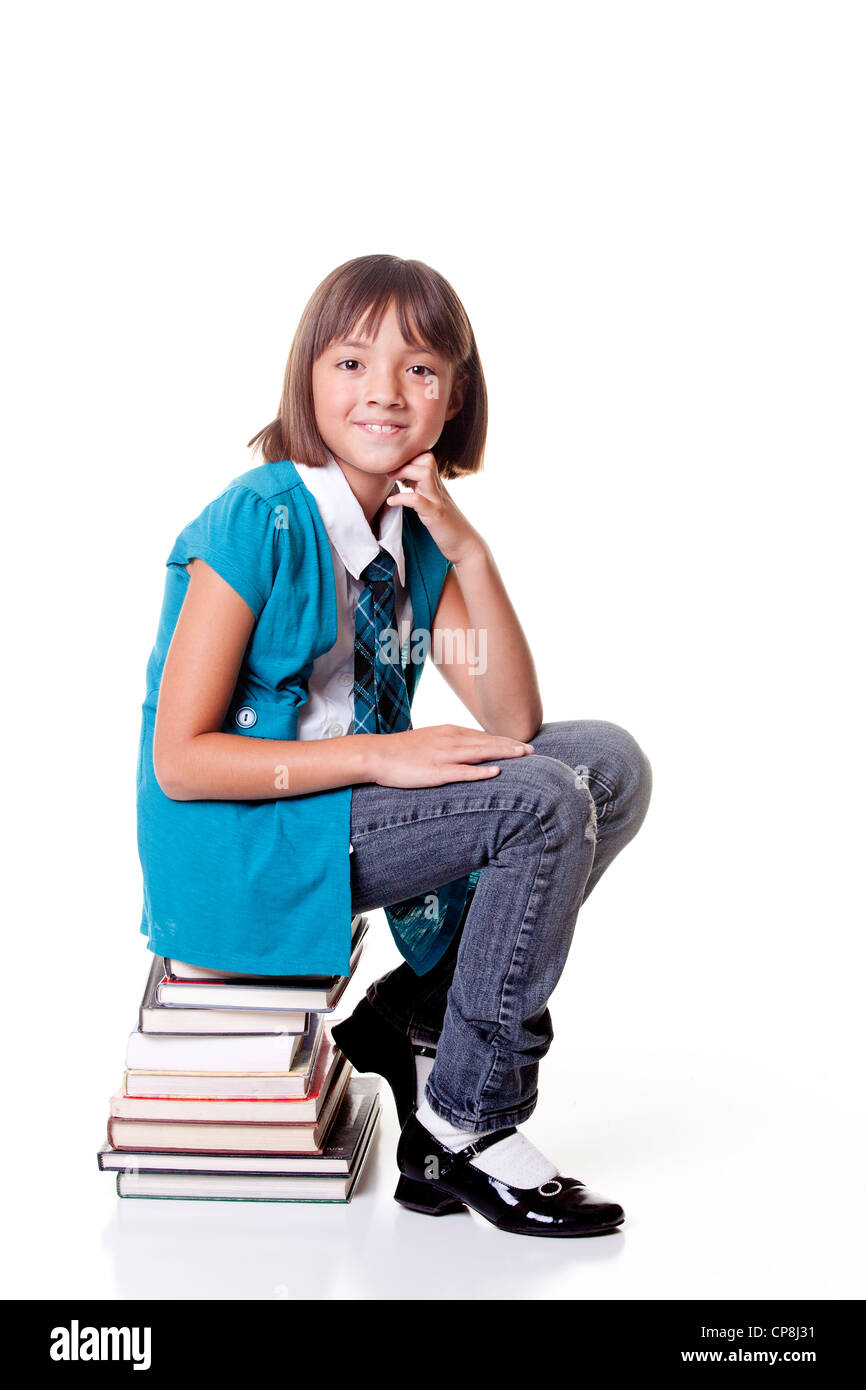 Student sits on a stack of books Stock Photo - Alamy