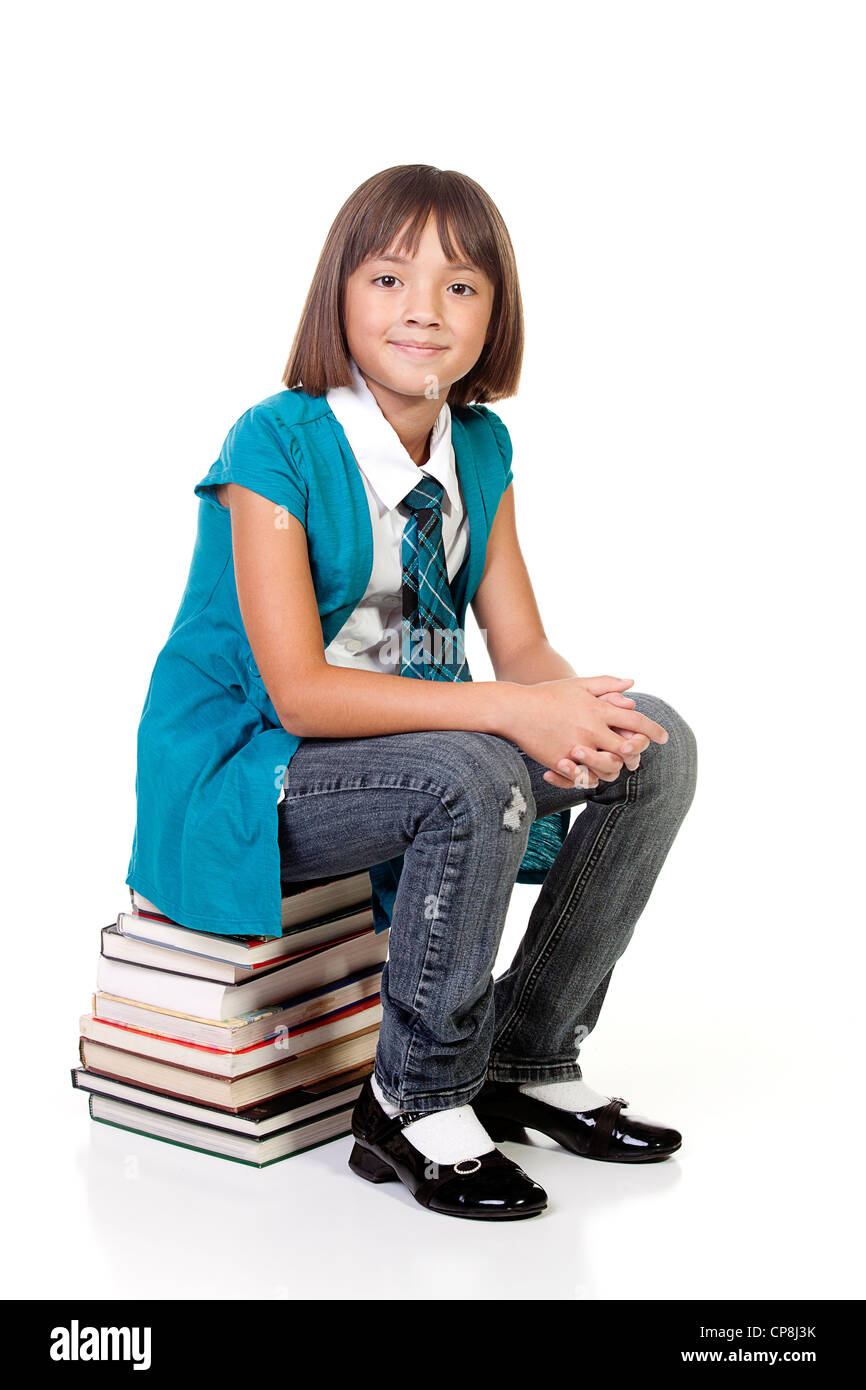 School girl sits on a stack of books Stock Photo - Alamy