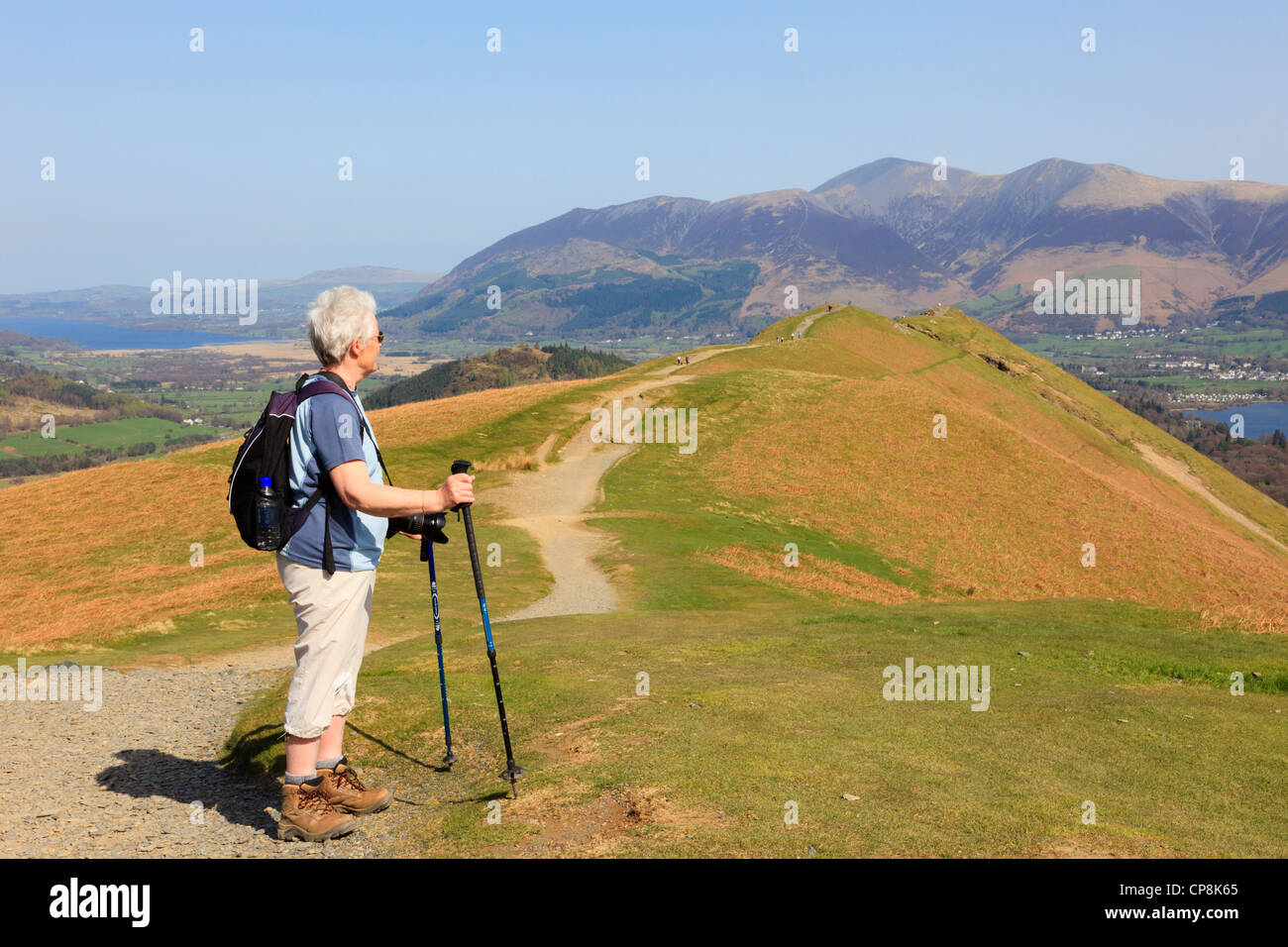 Active senior woman hill walking with trekking poles on a footpath to Catbells in Lake District National Park near Keswick Cumbira England UK Stock Photo