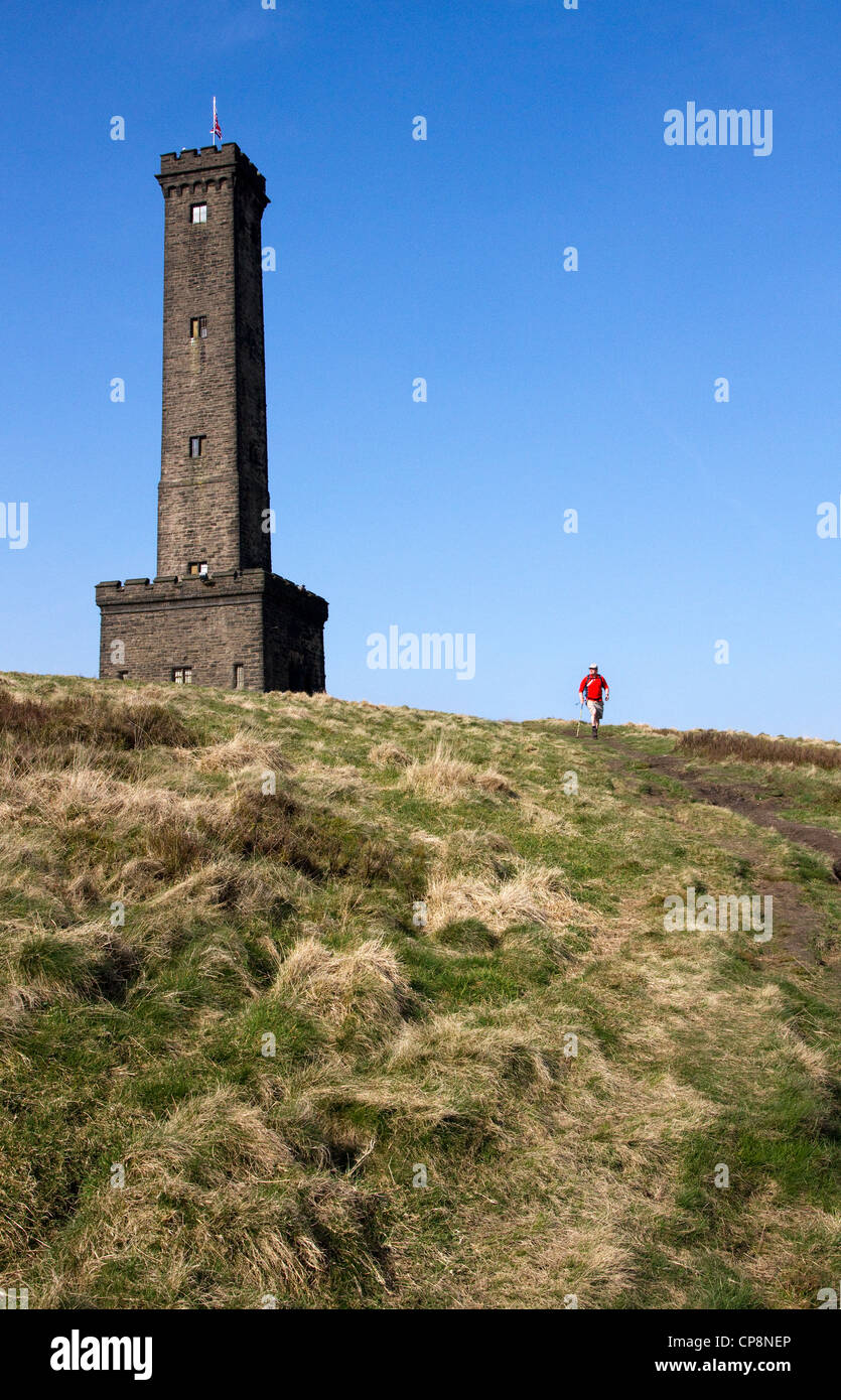 Walker passing Peel Tower, Holcombe Hill, above Ramsbottom, West Pennines, Greater Manchester / Lancashire, England,UK Stock Photo