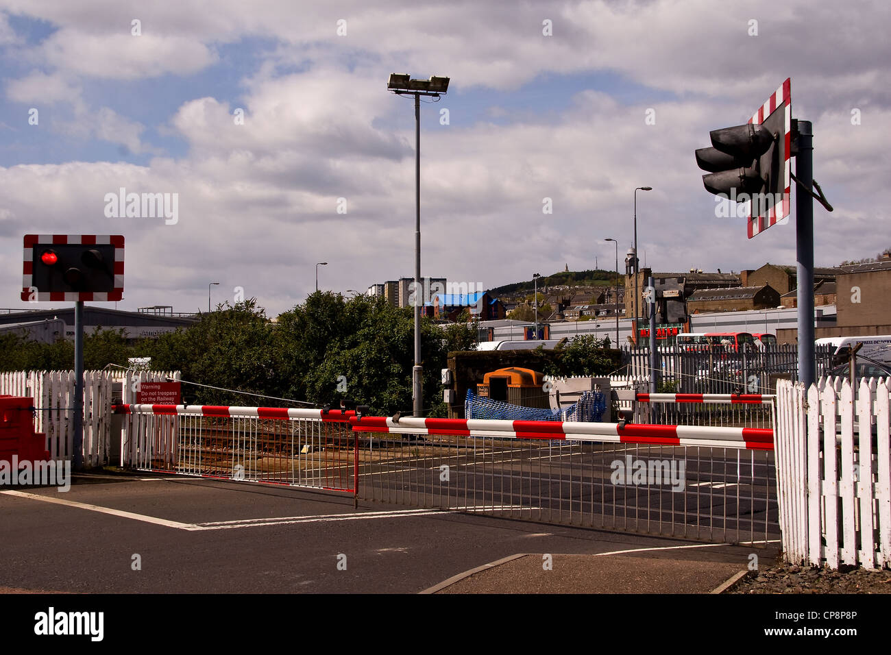 Barriers at the level crossing are closed due to a Scotrail train approaching the station in urban Dundee,UK Stock Photo