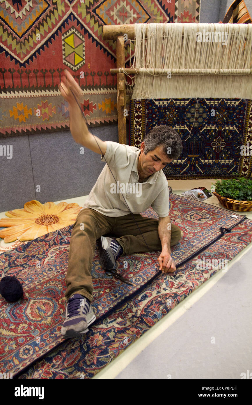 man sewing carpet by hand Stock Photo Alamy