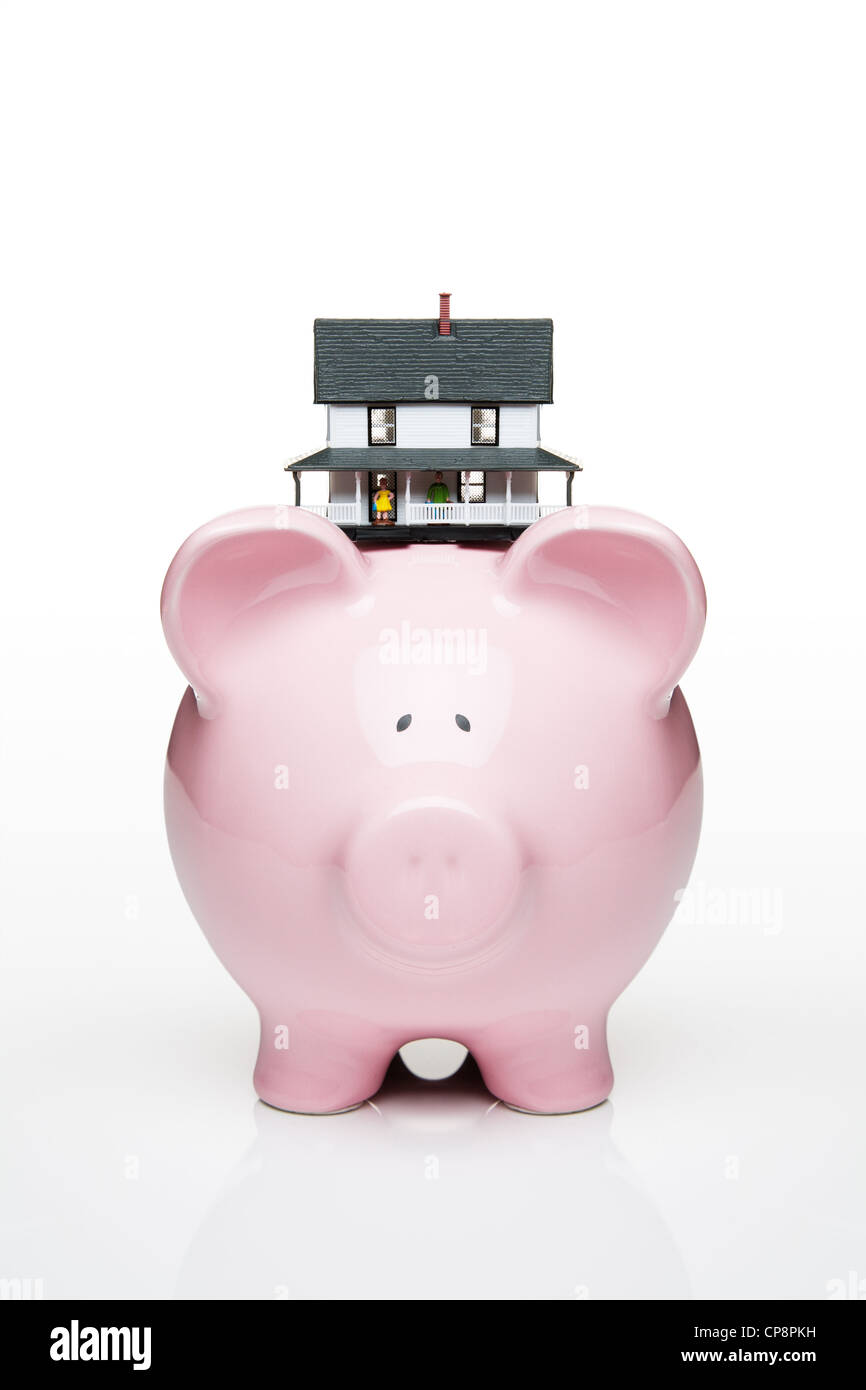 Toy house on a piggy bank Stock Photo