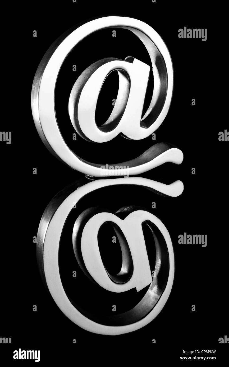 At symbol paperweight on reflective surface Stock Photo Alamy