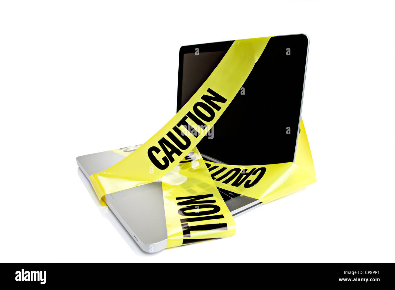 Laptop computer with caution tape wrapped around it Stock Photo