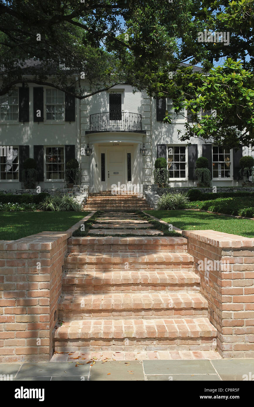 Brick steps leading to the shaded entrance to a large home in Austin, Texas Stock Photo