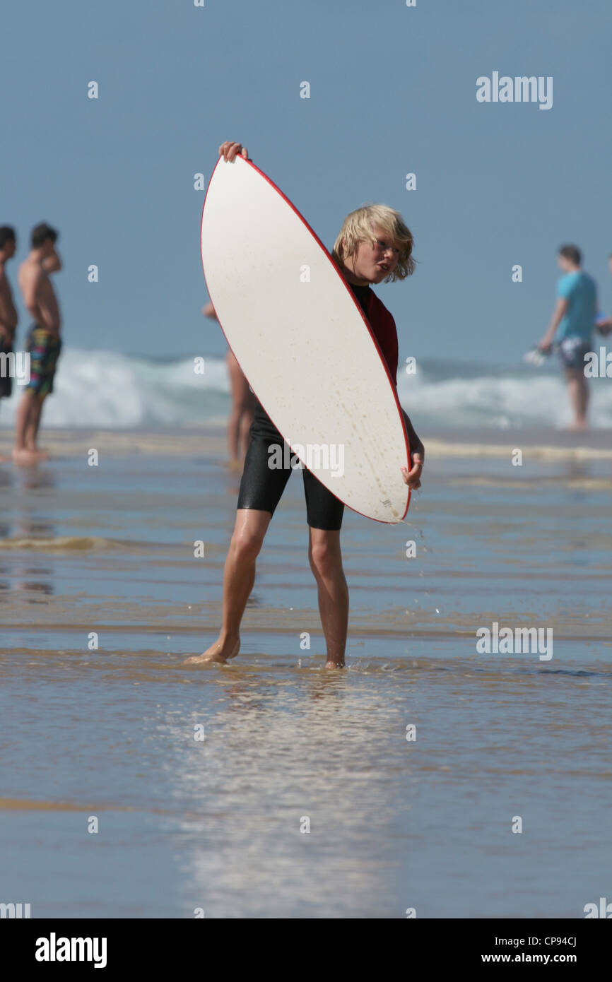 A teenager learning how to surf in shallow waters on the Atlantic coast