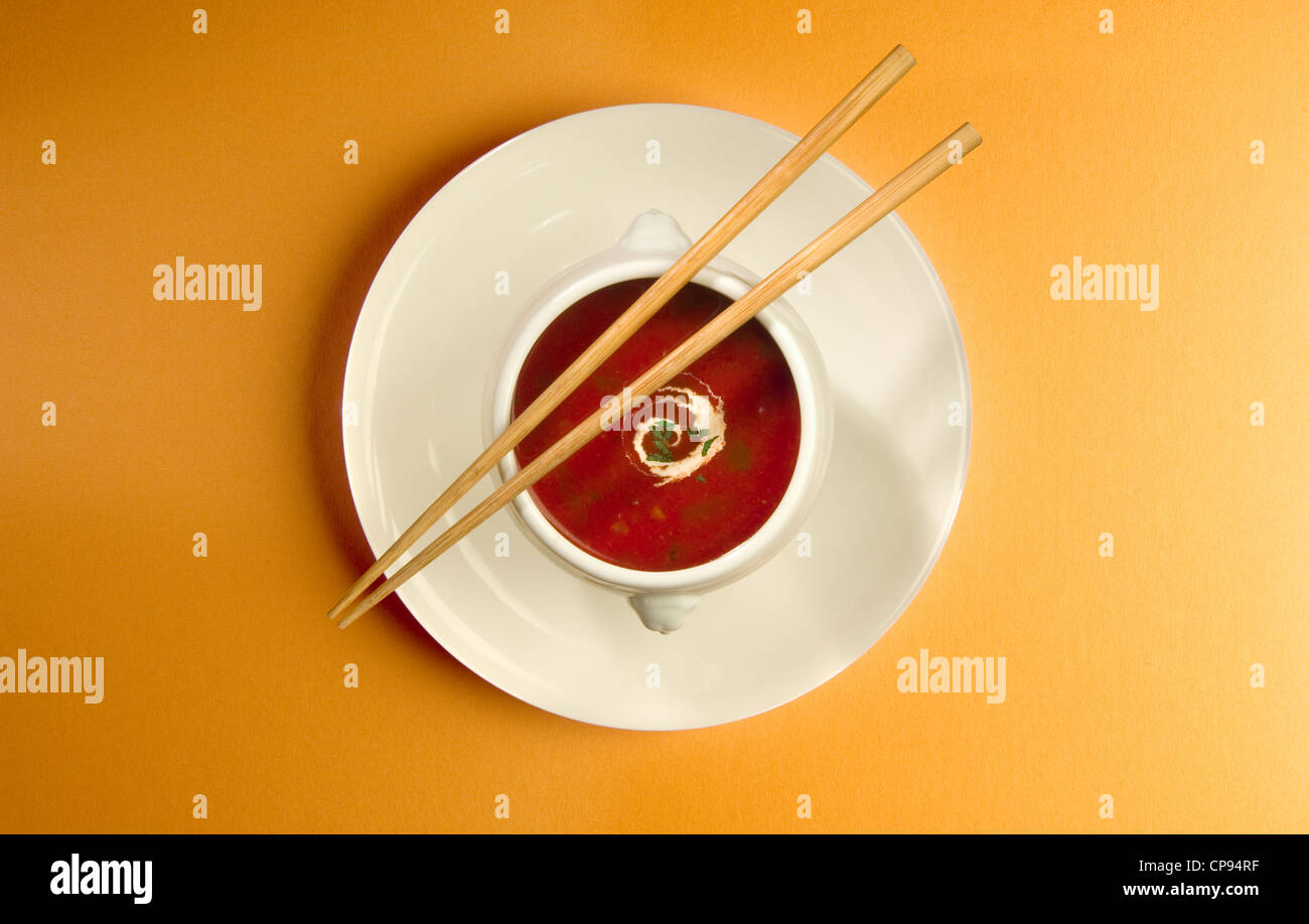 Chopsticks across a bowl of soup Stock Photo