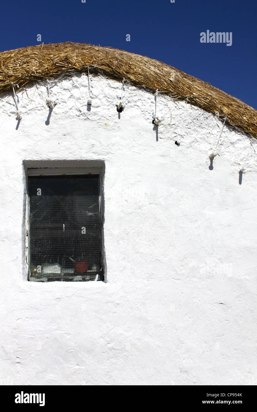 Detail of white-washed thatched cottage on the headland to Saint John's Point Stock Photo