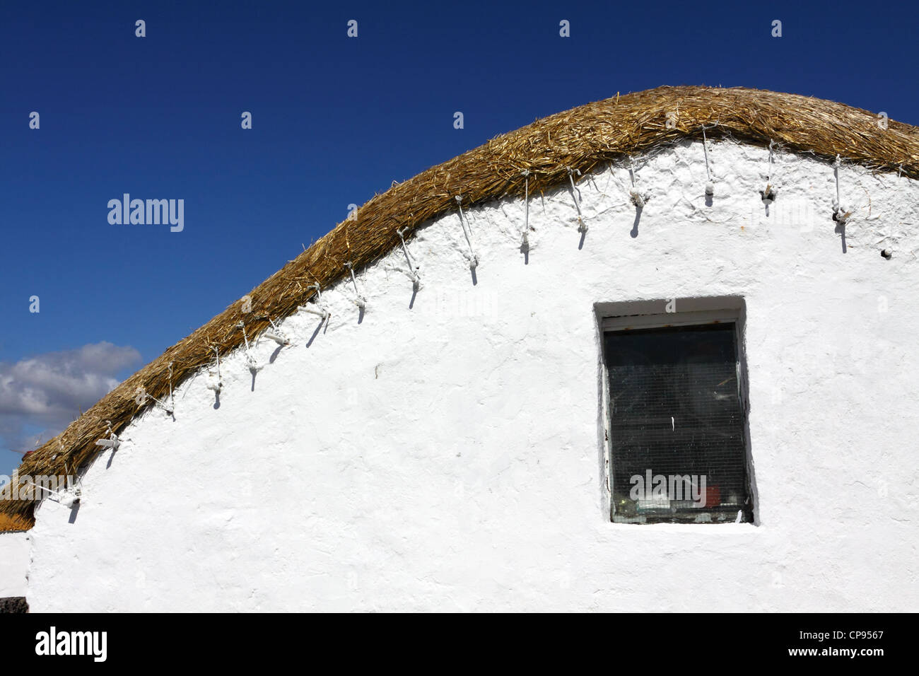 Detail of white-washed thatched cottage on the headland to Saint John's Point Stock Photo