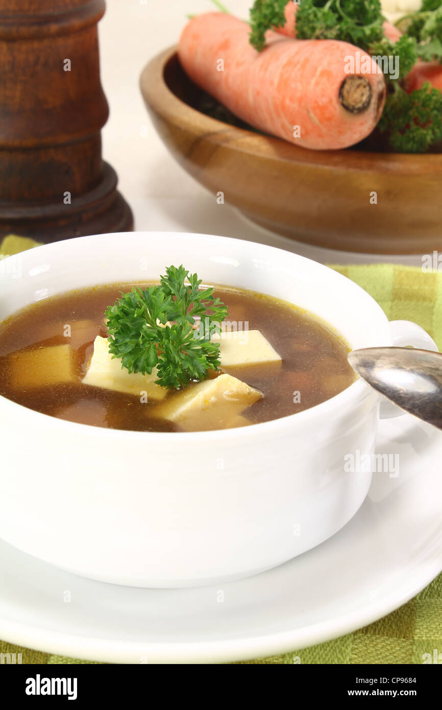 Beef consomme with fresh soup vegetables, egg and parsley Stock Photo
