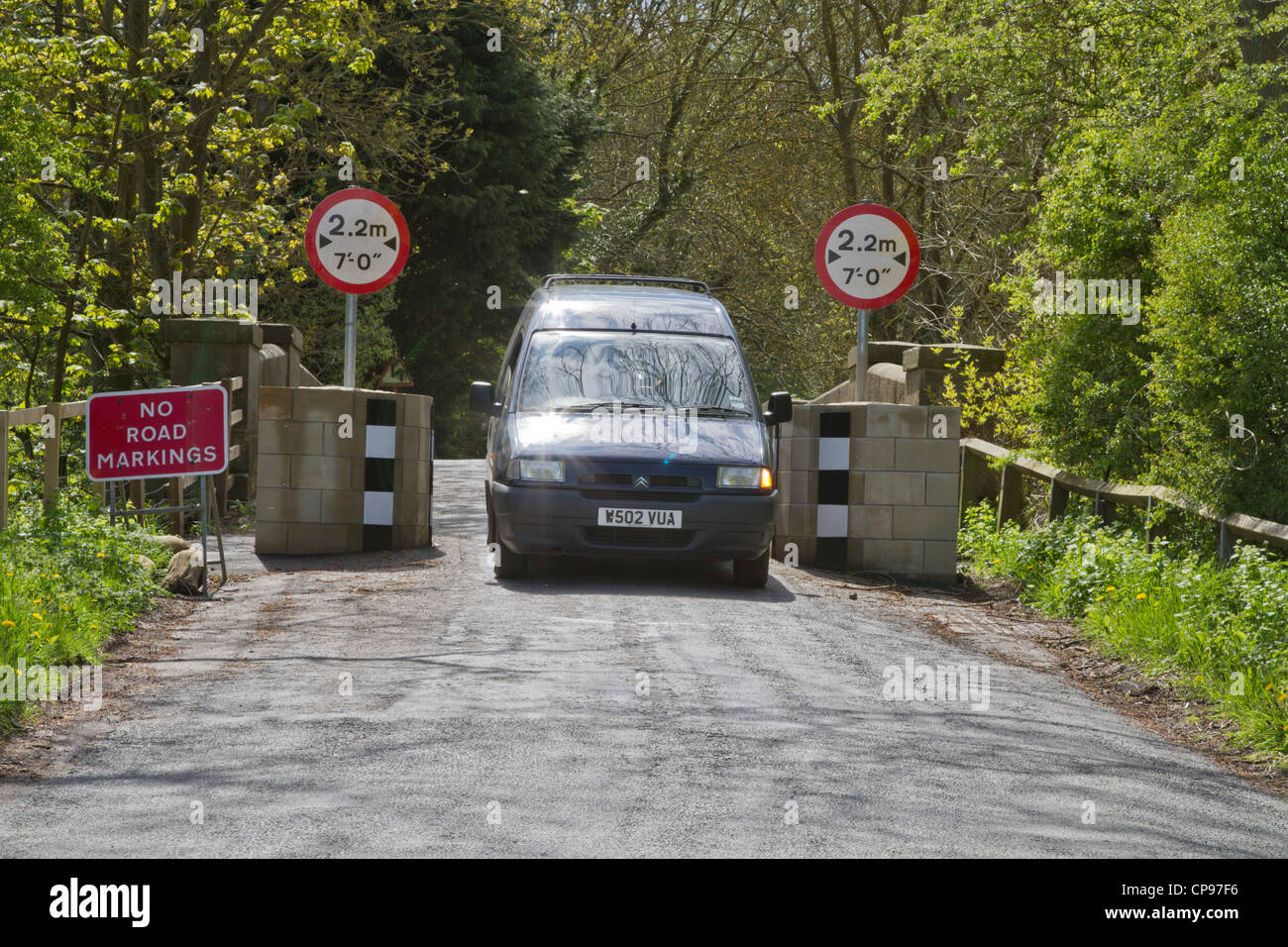 Van passing through bollards protecting an ancient narrow bridge at Buttercrambe near York UK. Stock Photo