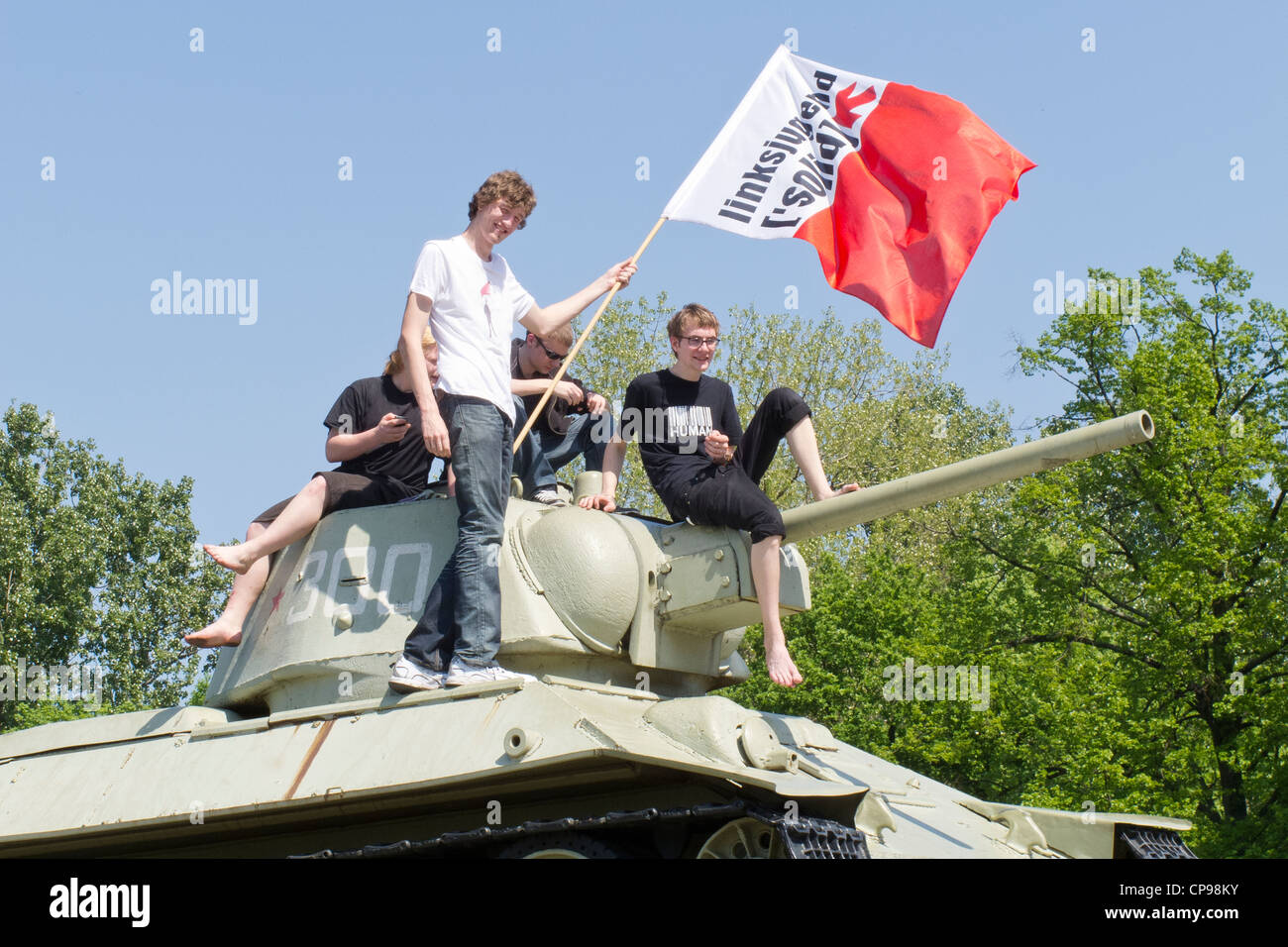 Berlin - The Russian War Memorial and tank. 17 Juni Strasse - May day celebrations with young men on the tank. Stock Photo