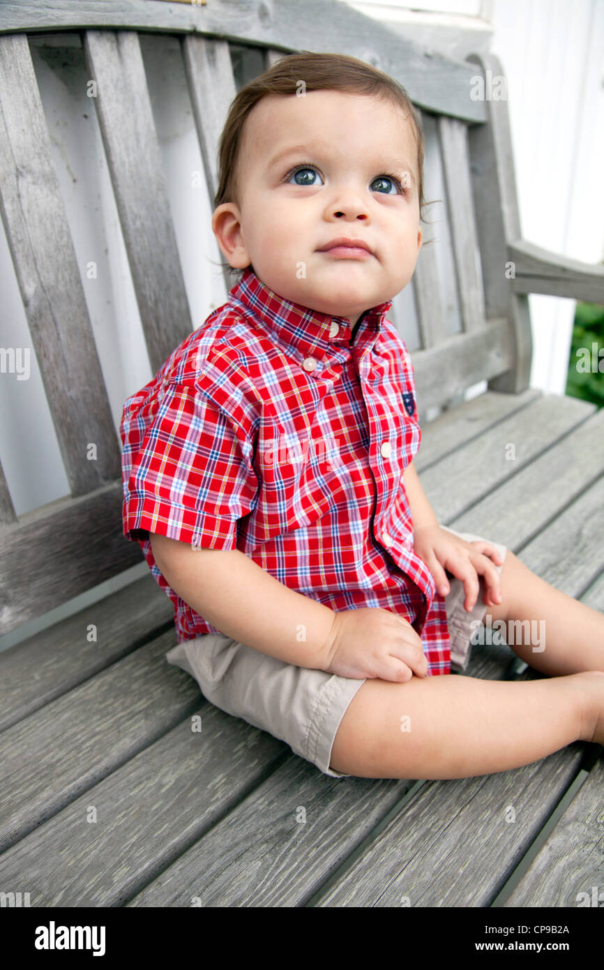 Young Boy Sitting on Bench and Looking Up Stock Photo - Alamy