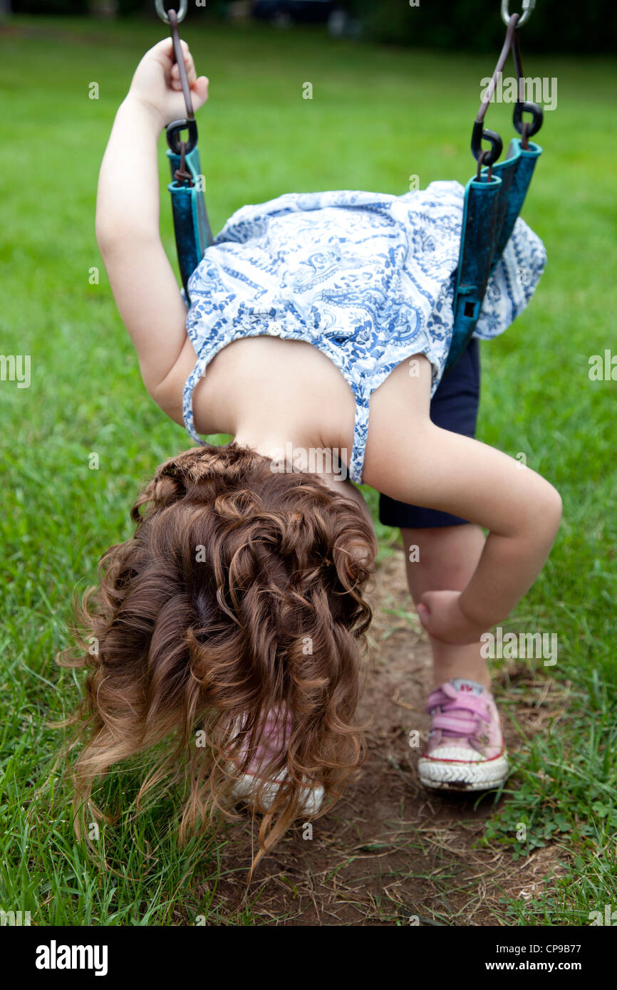 Young Girl Bending Over on Swing Stock Photo - Alamy