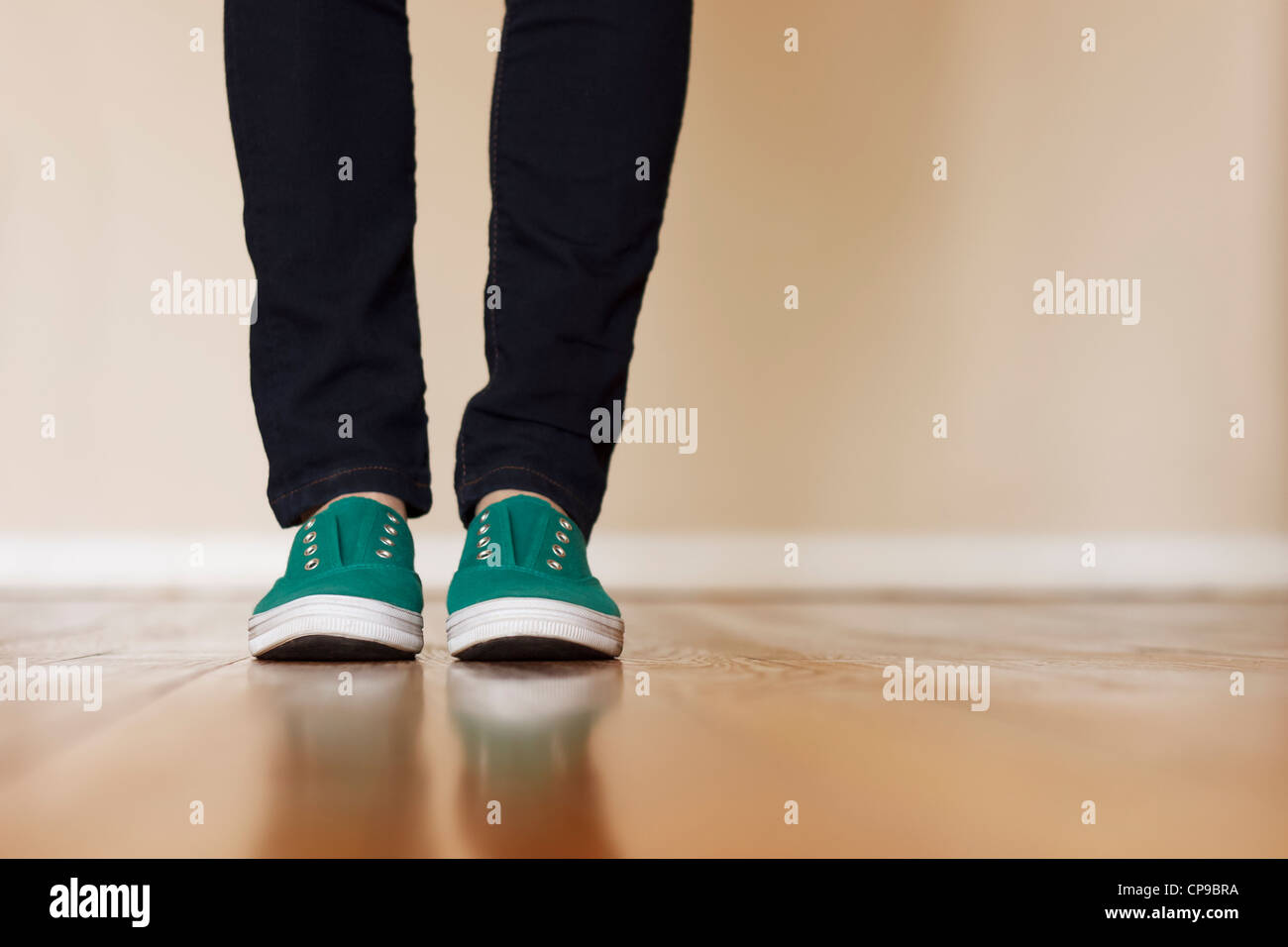 Green canvas sneakers standing on wooden floor Stock Photo - Alamy