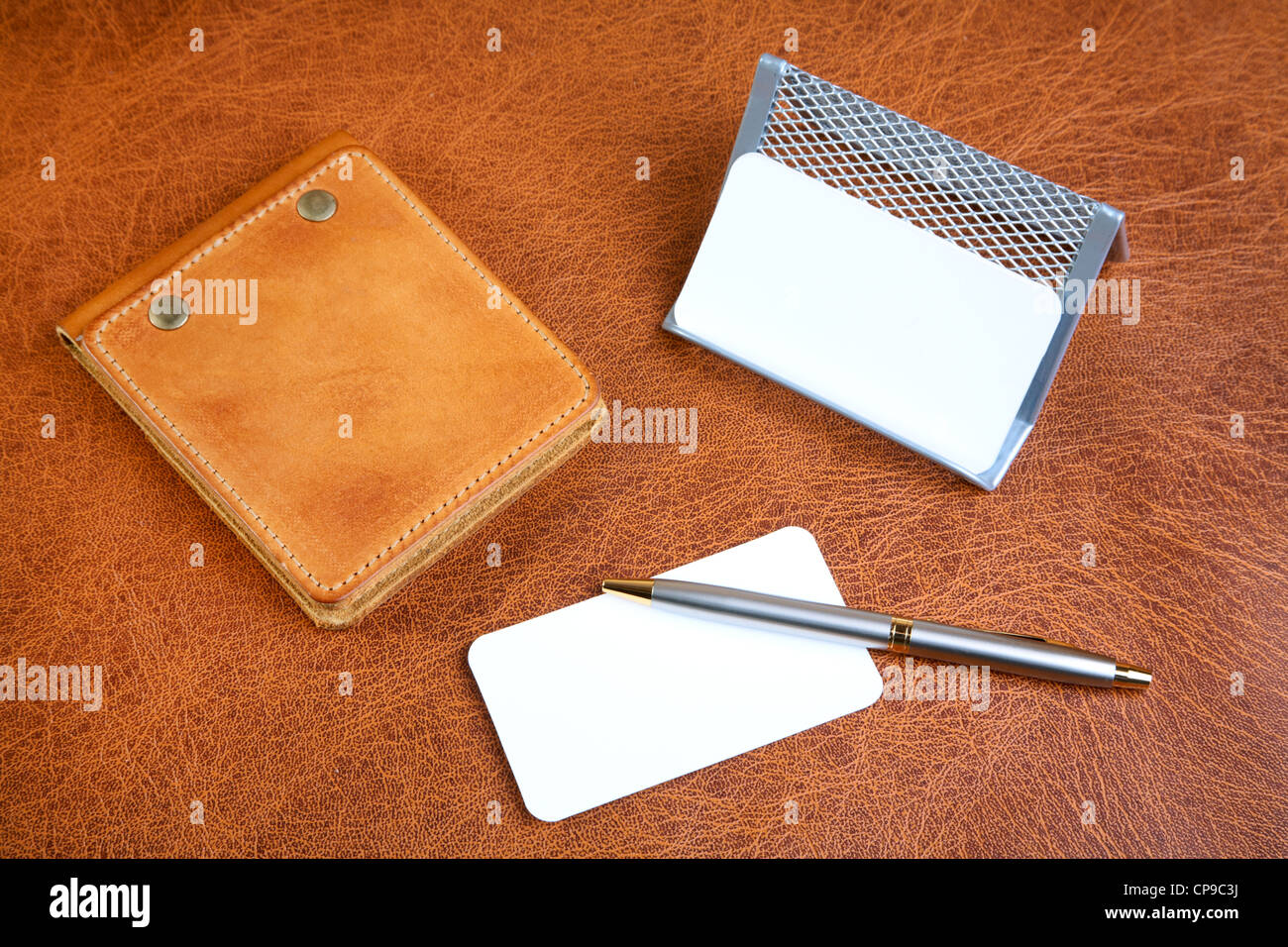 Leather organizers and pen on a textural background Stock Photo