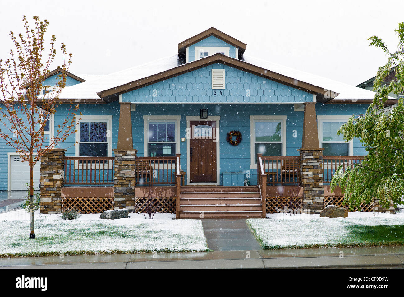 Fresh springtime snow blankets a Craftsman Style residential home in Colorado, USA Stock Photo