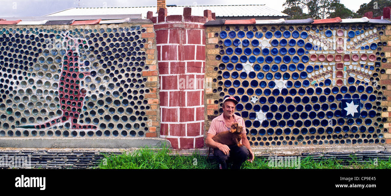bottle artist Kurt Brasche with home-made patriotic wall outside his home in Northcliffe, SW Western Australia Stock Photo