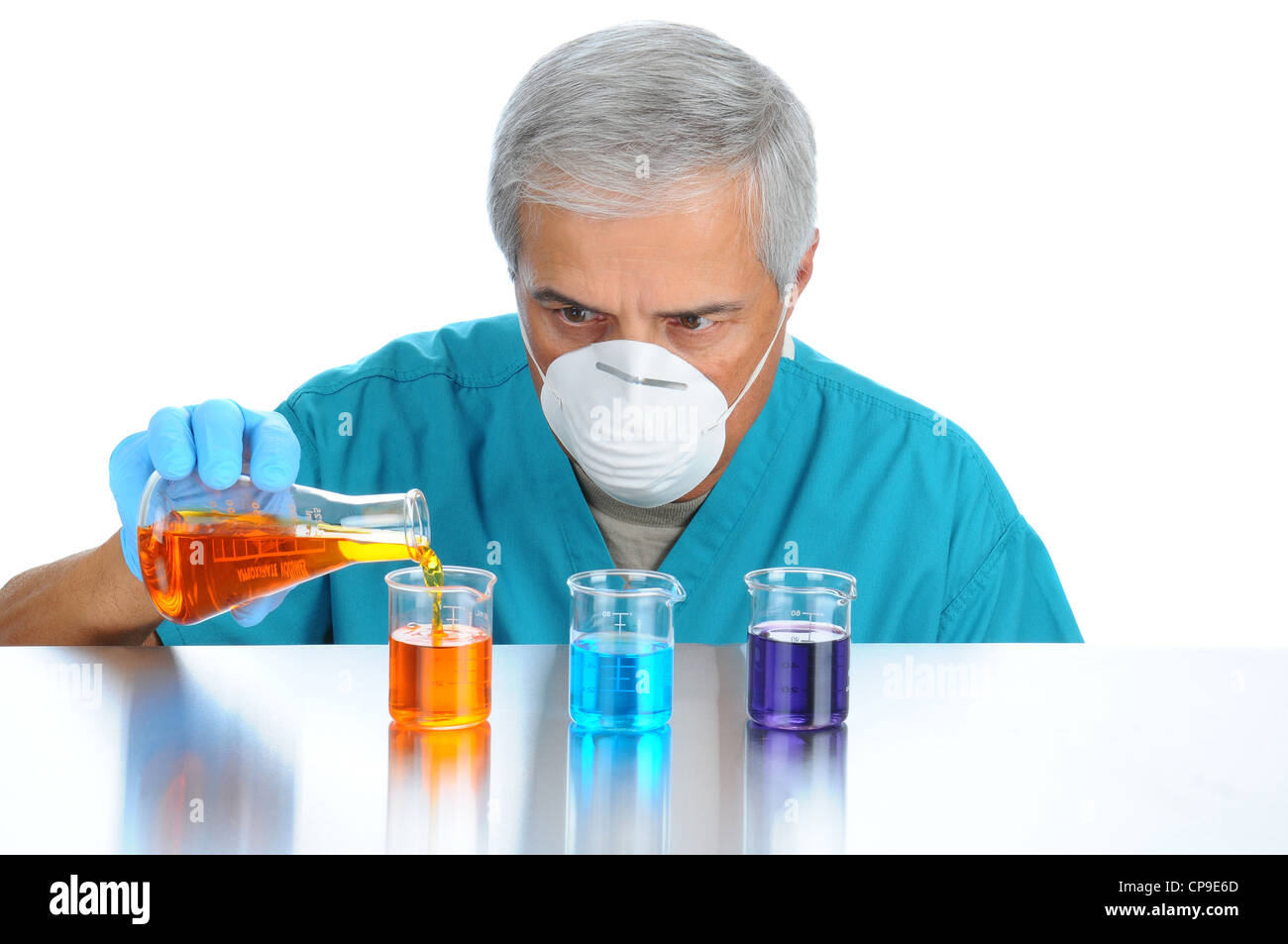 Scientist pouring measuring liquids in assorted beakers. Horizontal format over white background. Stock Photo