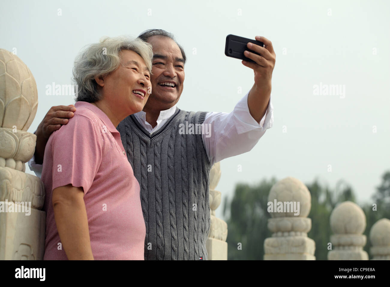 Older couple smiling and taking a photo of each other Stock Photo