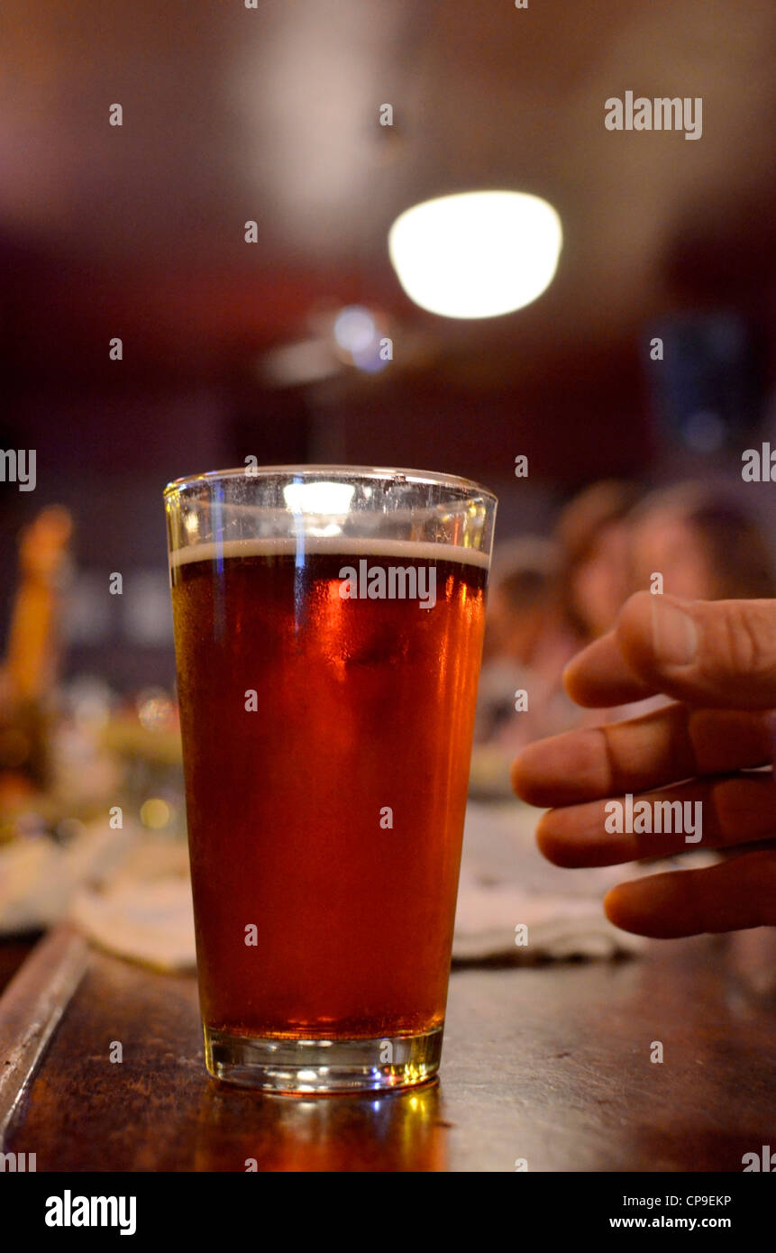 Reaching for a pint of beer on the bar at Ten Depot Street, La Grande, Oregon. Stock Photo