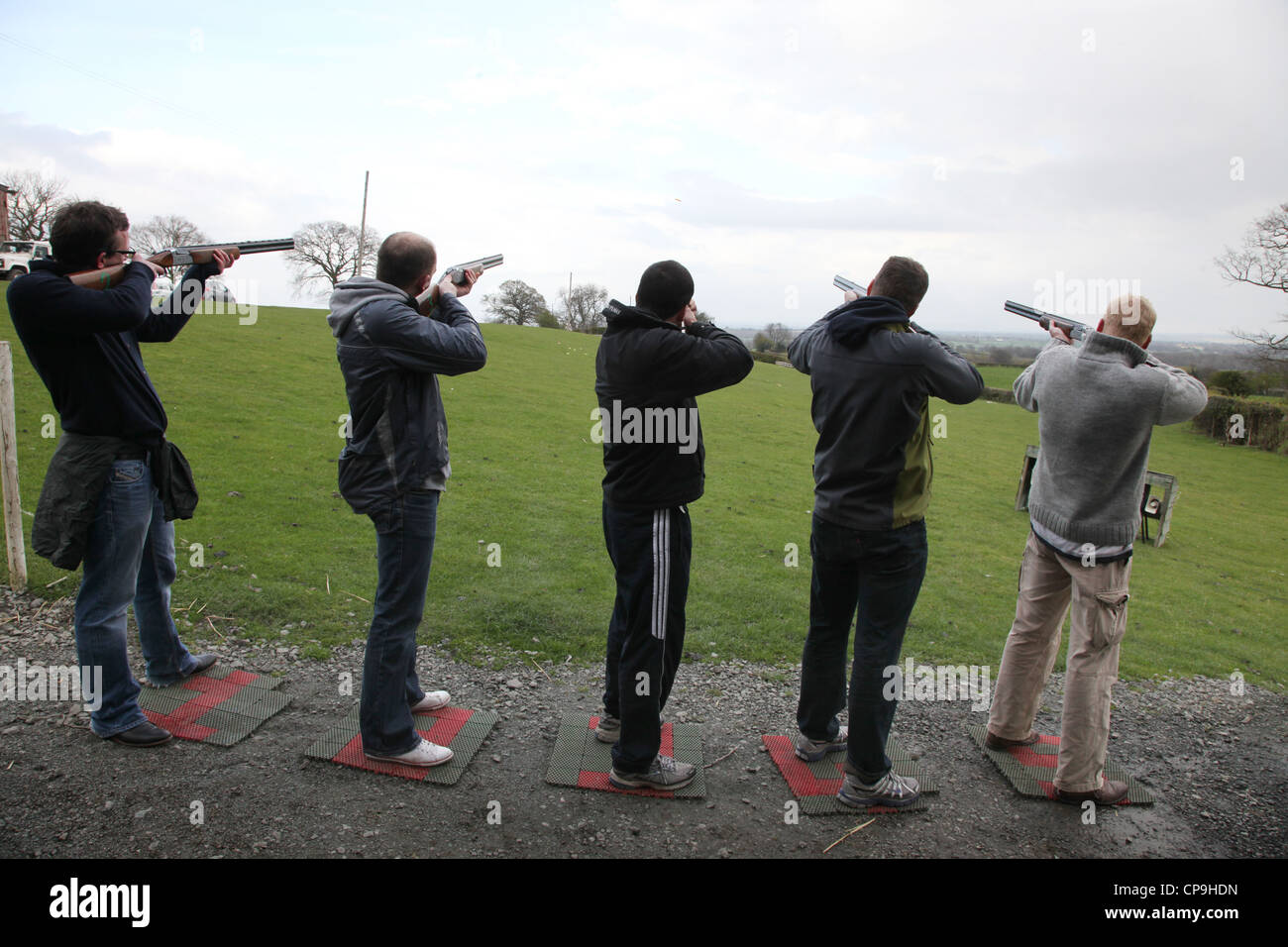 Men participate in a clay pigeon shooting competition for fun on a