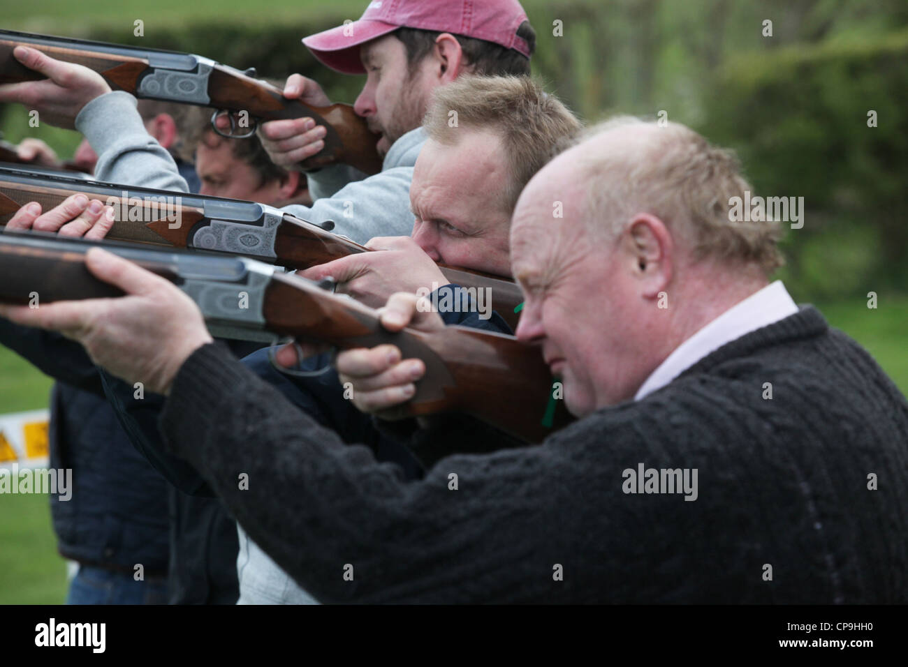 Men participate in a clay pigeon shooting competition for fun on a