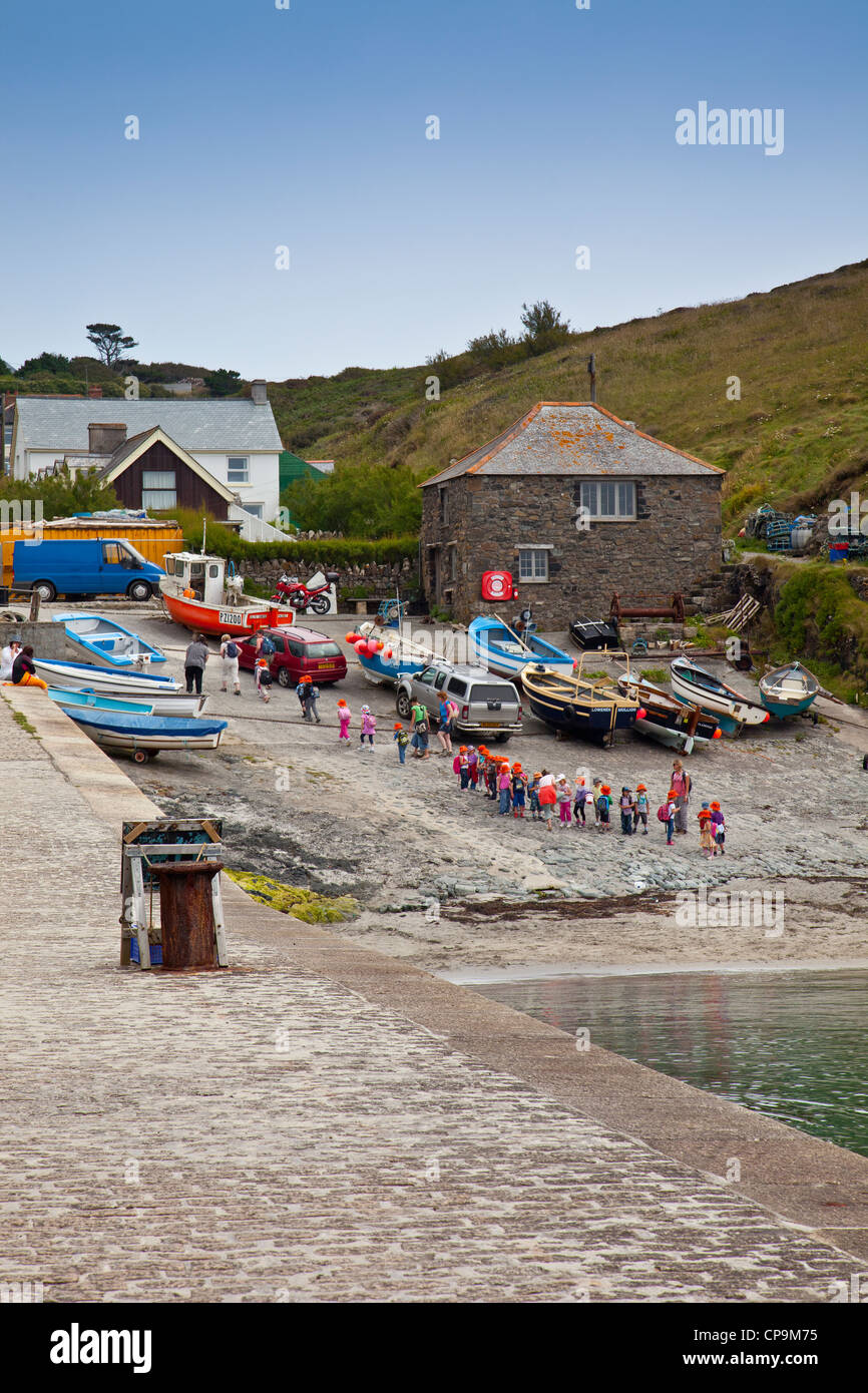 A party of primary school children leaving the harbour at Mullion Cove on the Lizard Peninsula, Cornwall, England, UK Stock Photo