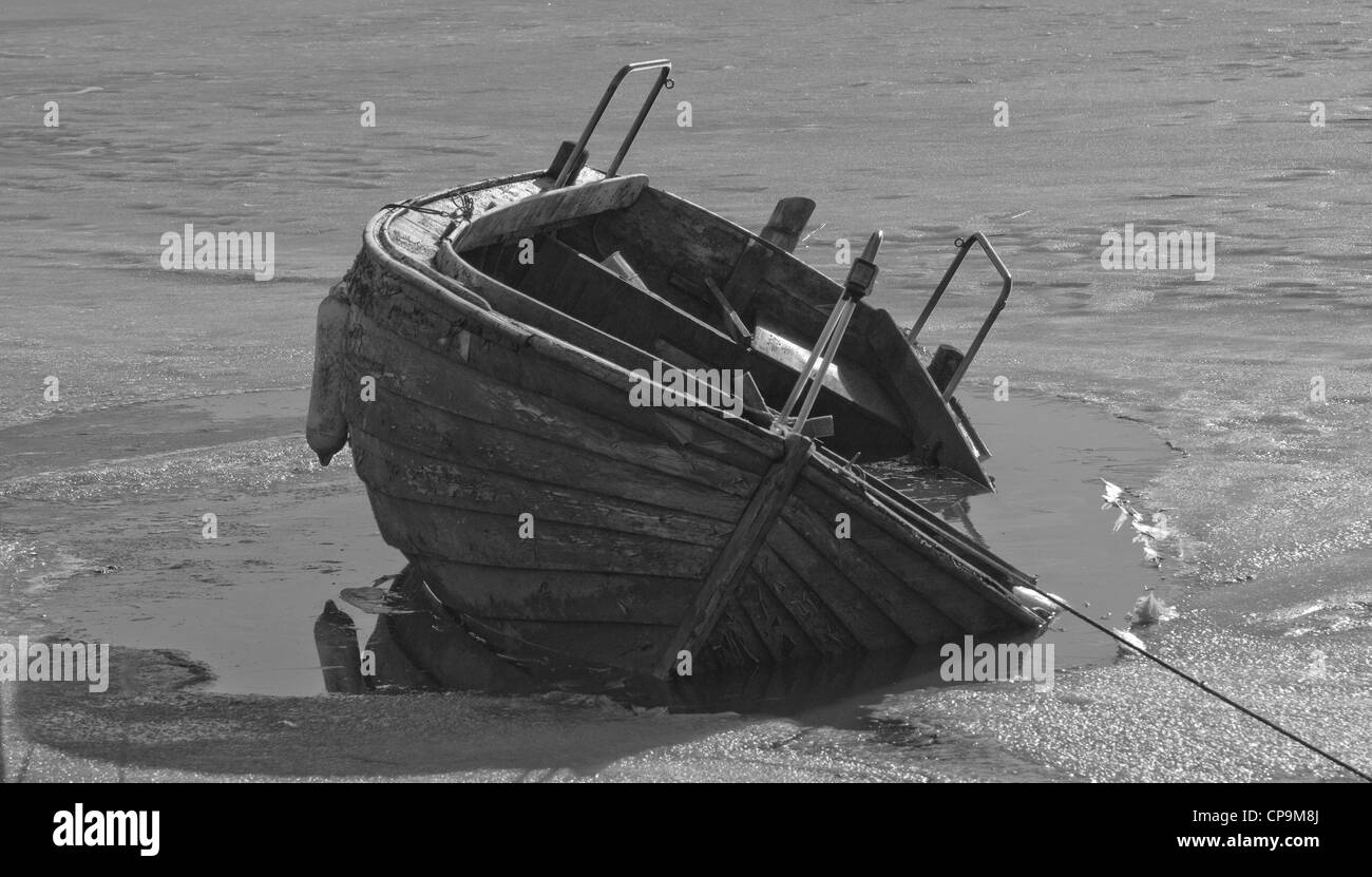 Small Fishing Boat trapped in the winter ice Stock Photo