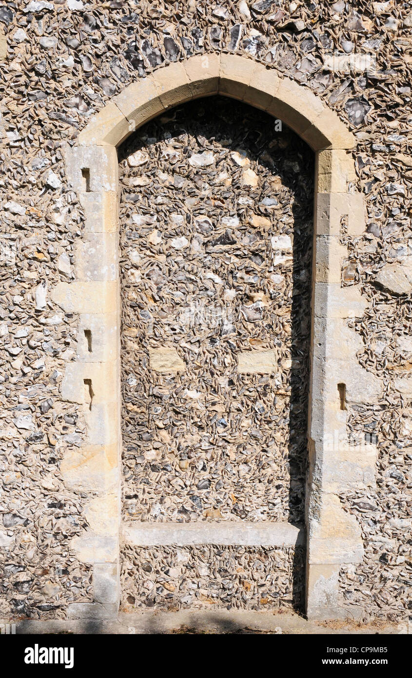 Blocked up doorway in Boxgrove Priory Church. Intricately galleted knapped flintwork. Stock Photo