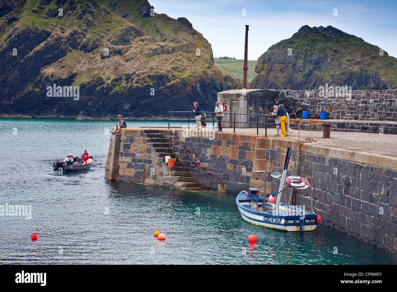 Fishing boats in and leaving the harbour at Mullion Cove on the Lizard Peninsula, Cornwall, England, UK Stock Photo