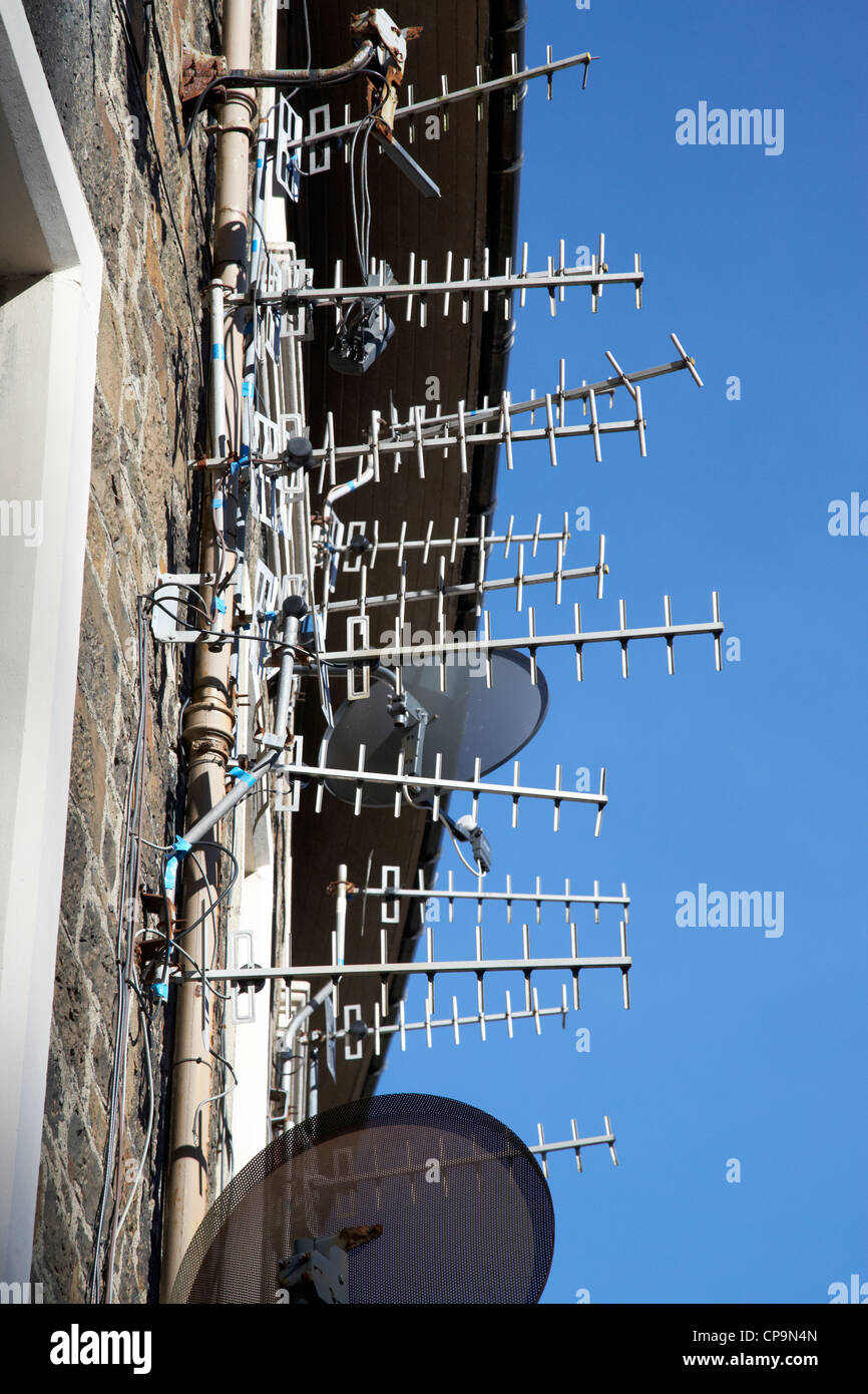 large amount of tv aerials and satellite receivers on a wall of a