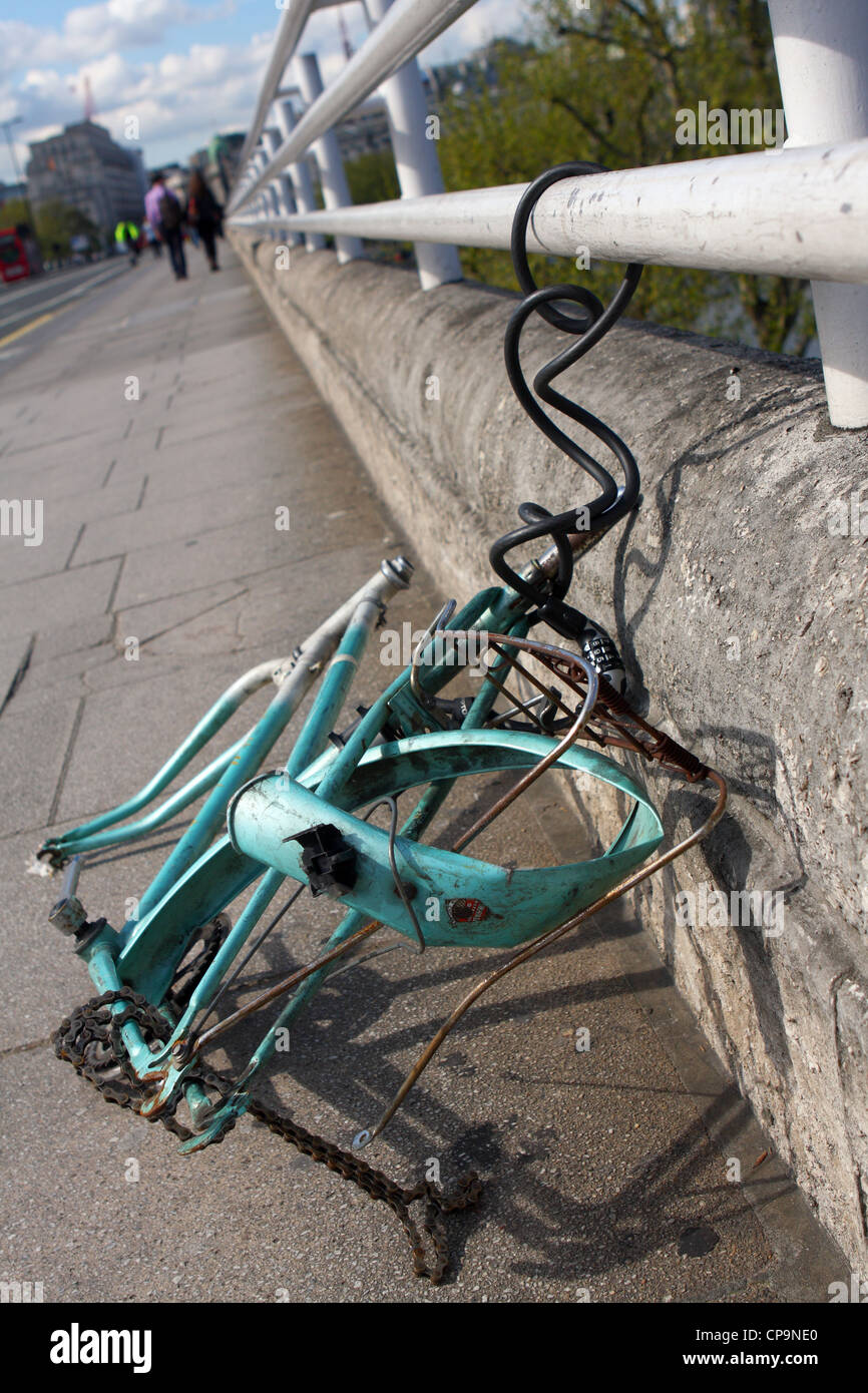 a broken cycle still chained to railings on Westminster Bridge in London Stock Photo