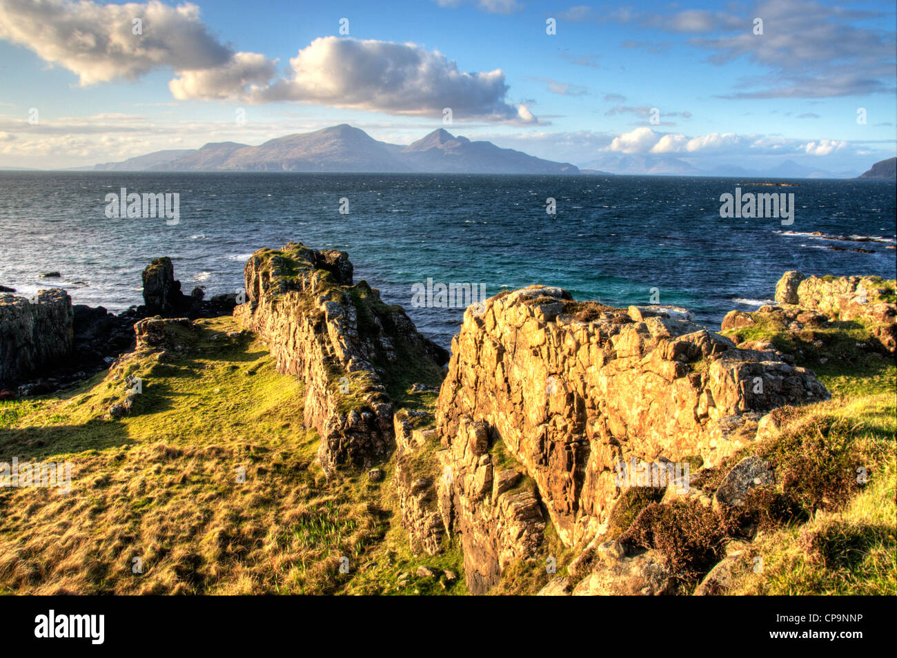 landscape of isle of muck with strong foreground interest and the isle of rum in the back ground small isles scotland Stock Photo