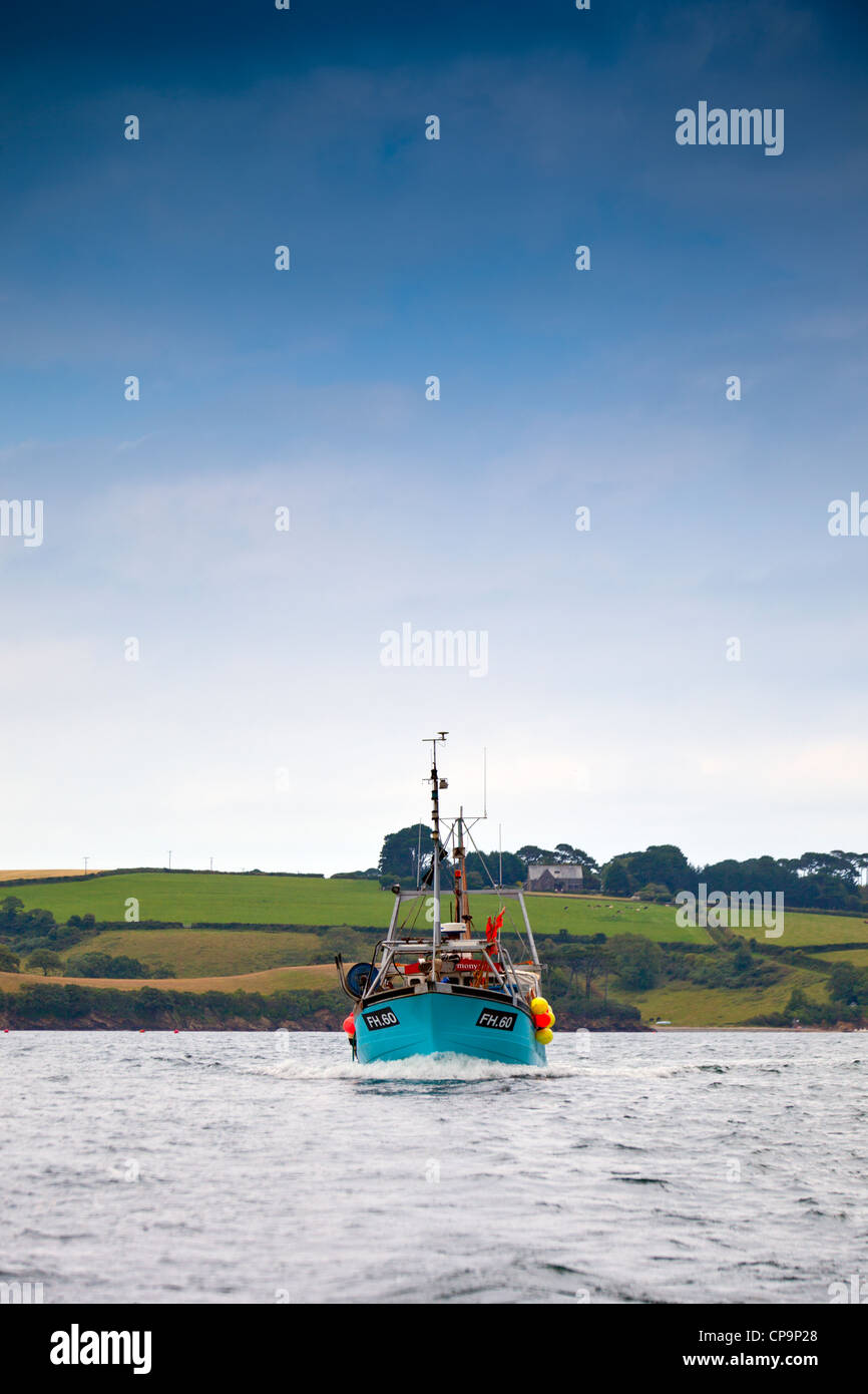 A fishing boat approaching the oyster beds on the Helford River in Cornwall, England, UK Stock Photo