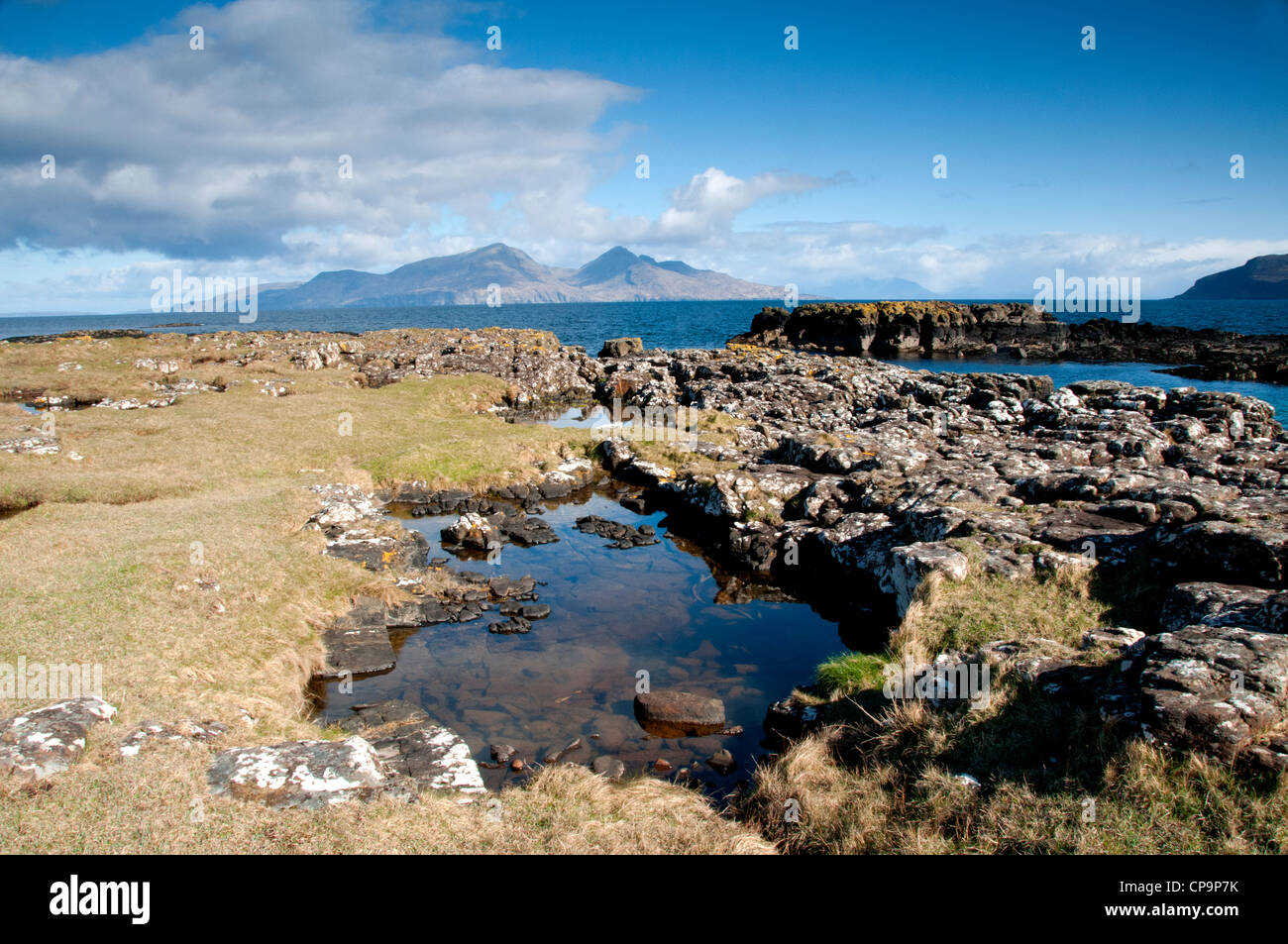 a landscape of isle of muck with isle of rum in the back ground with good foreground interest off the west coast of scotland Stock Photo