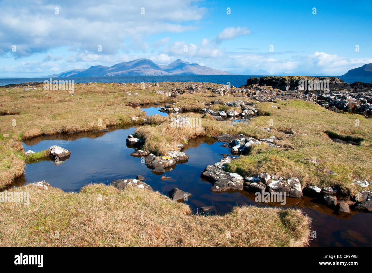 landscape of the isle of muck with good foreground interest with the isle of rum in the back ground off the west coast scotland Stock Photo