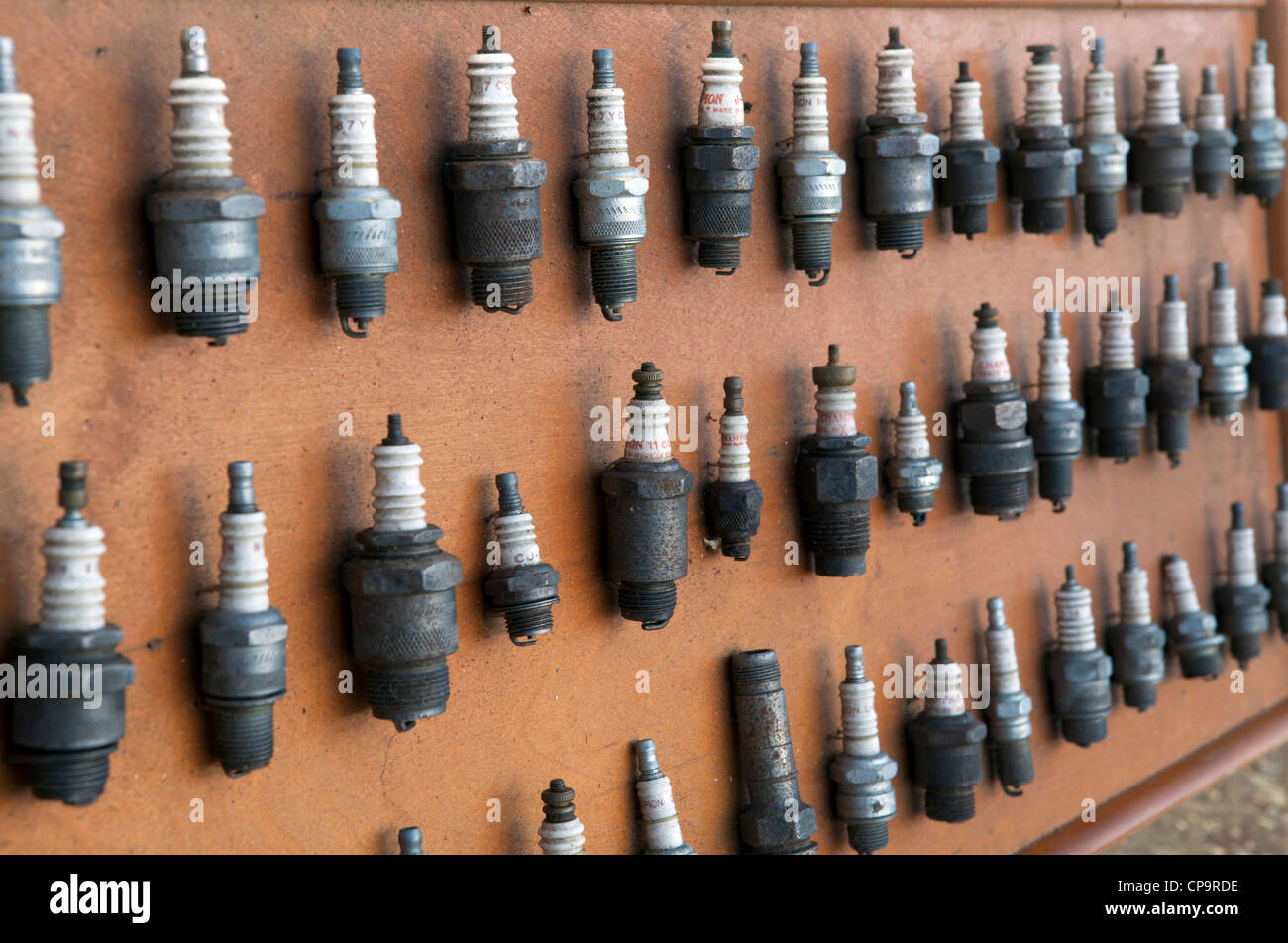 Collection of old spark plugs displayed on a board Stock Photo