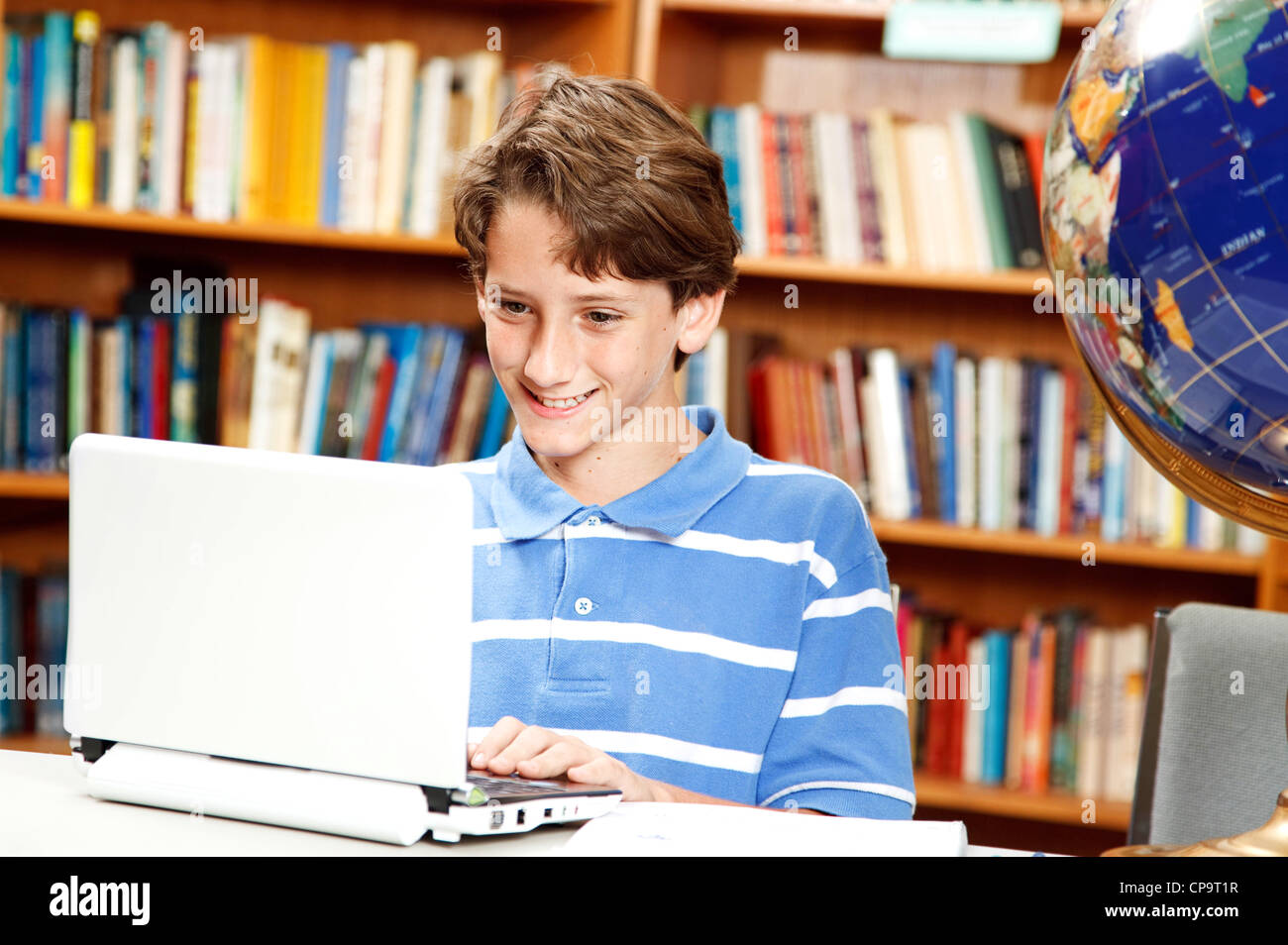 Cute little boy using a netbook computer in the school library Stock ...