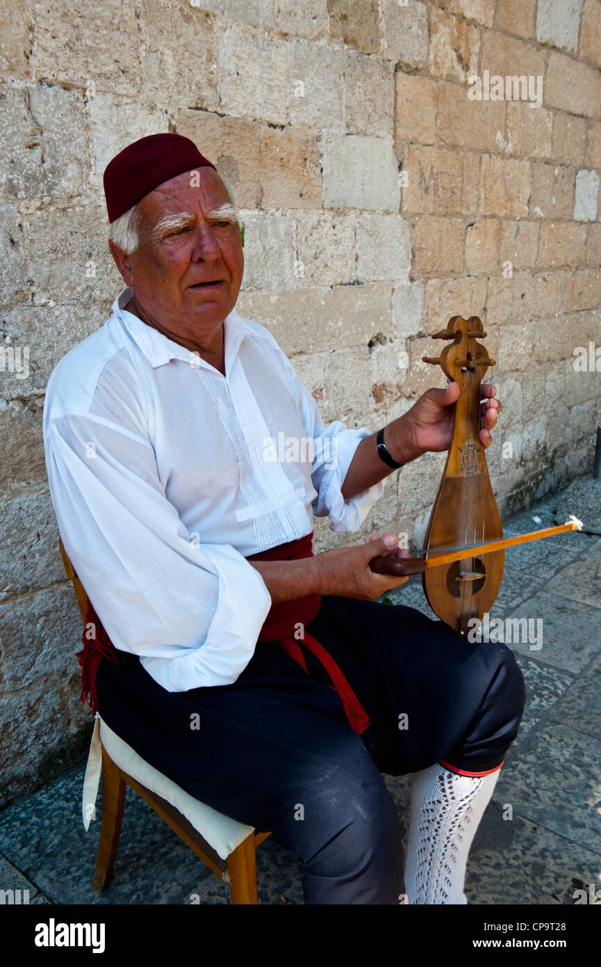 Street musician in historic medieval costumes playing a stringed instrument, Old Town, Dubrovnik. Croatia. Stock Photo