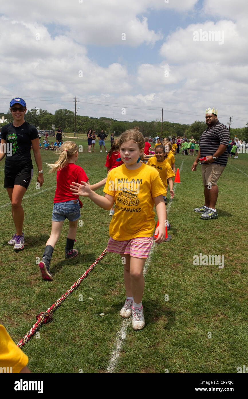 Second grade elementary school age kids participate in tugofwar