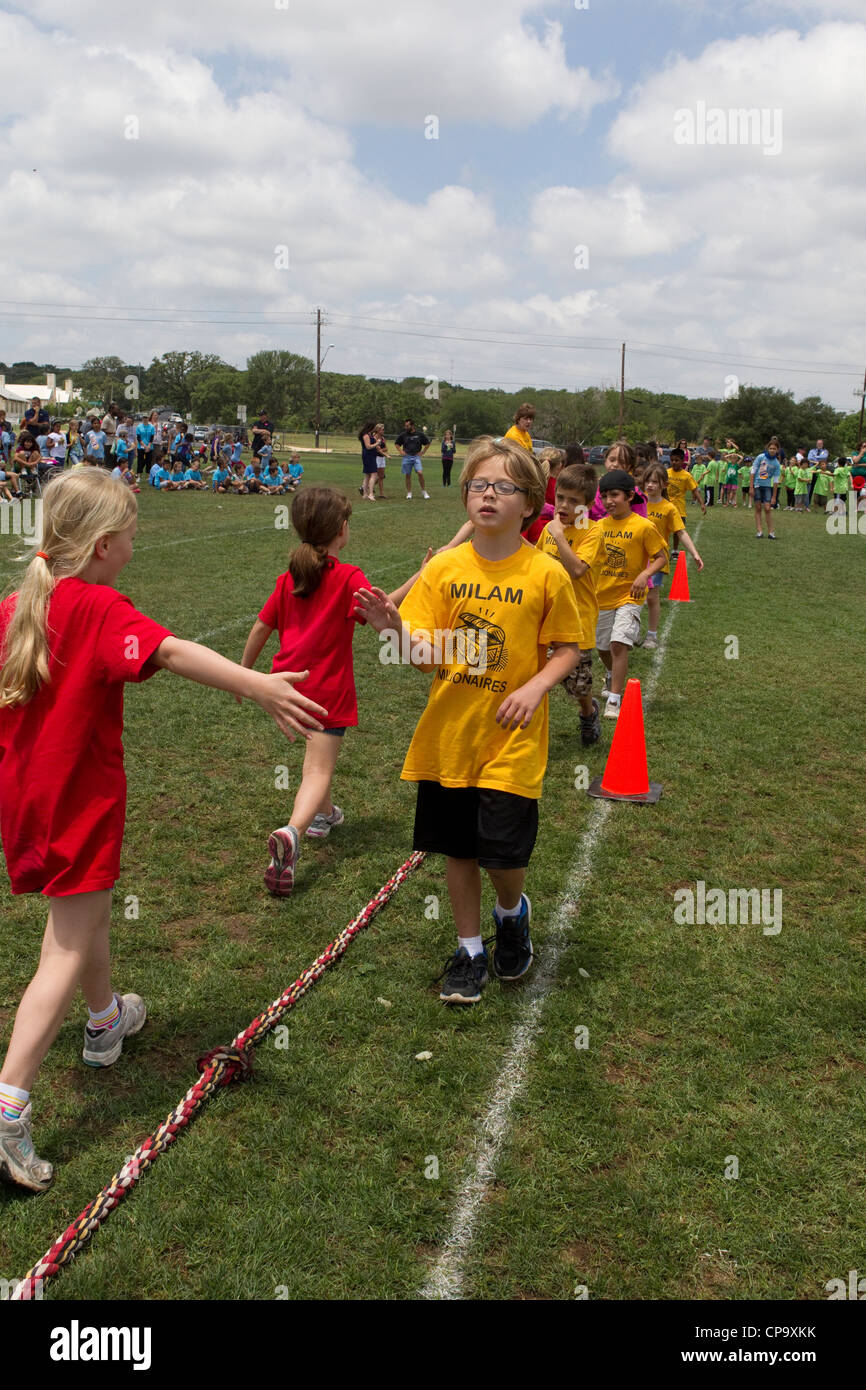 Second grade elementary school age kids participate in tugofwar