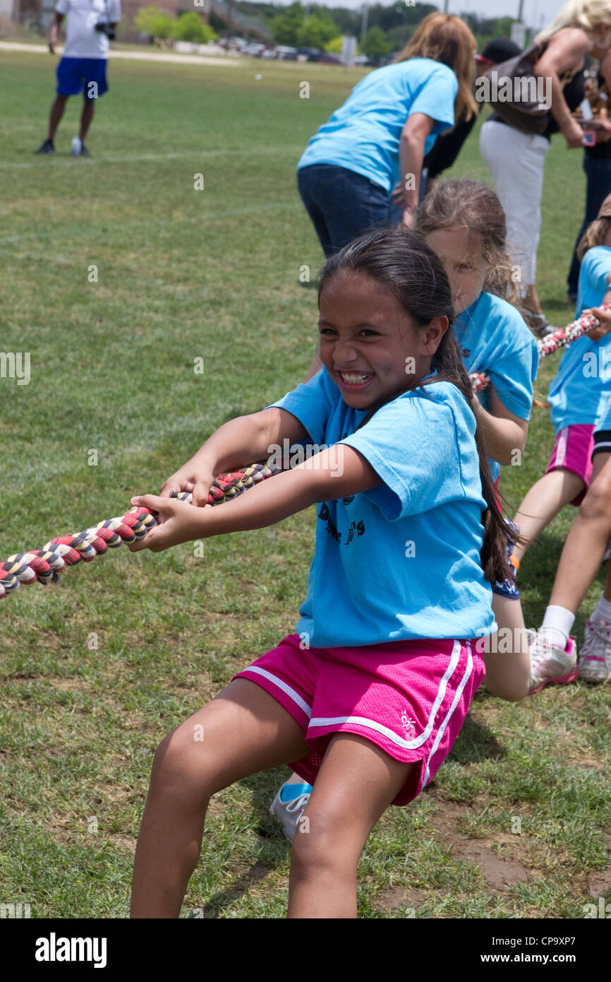 Second grade elementary school age kids participate in tugofwar