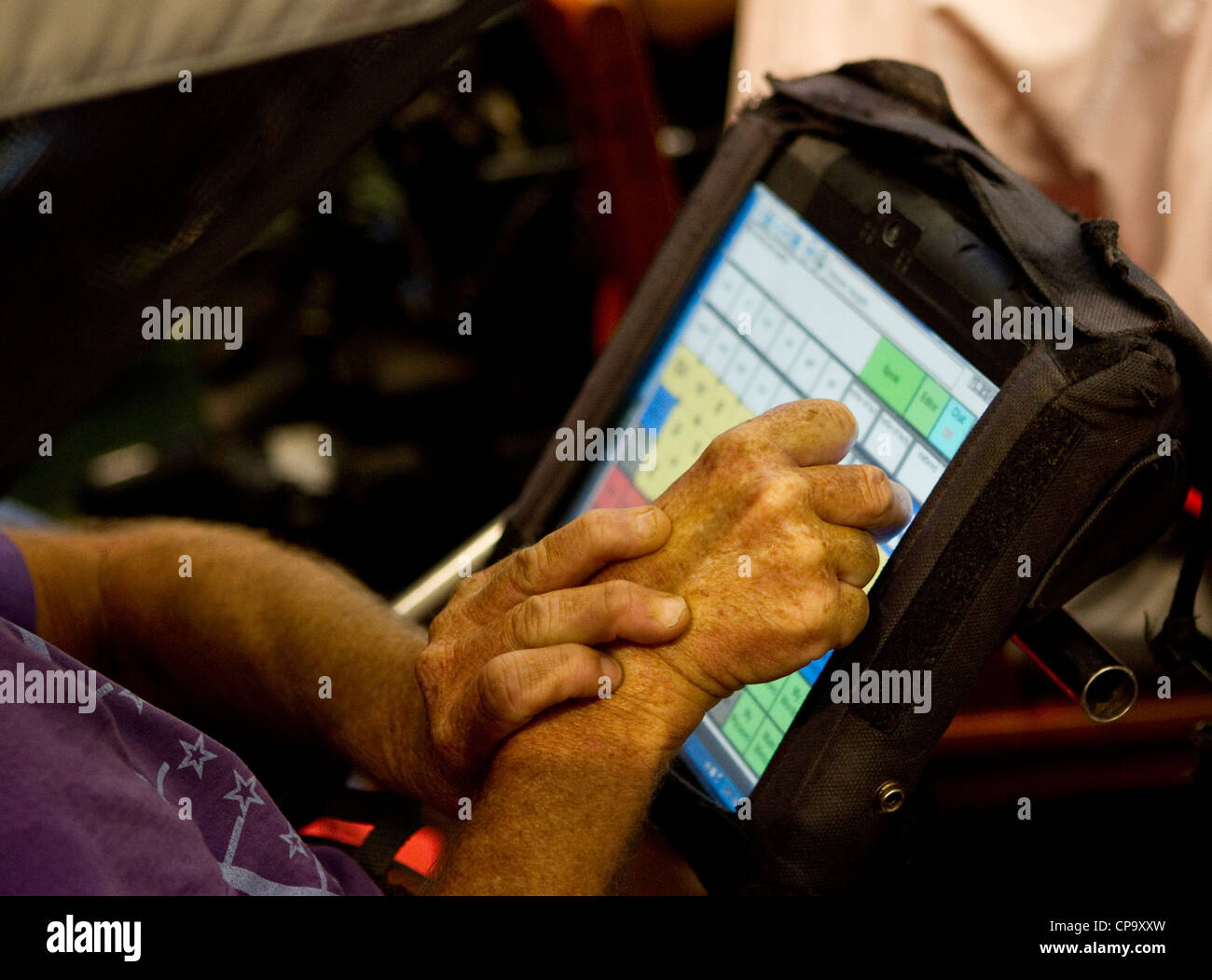 Physically disabled man uses special computer keyboard on his wheelchair to communicate Stock Photo