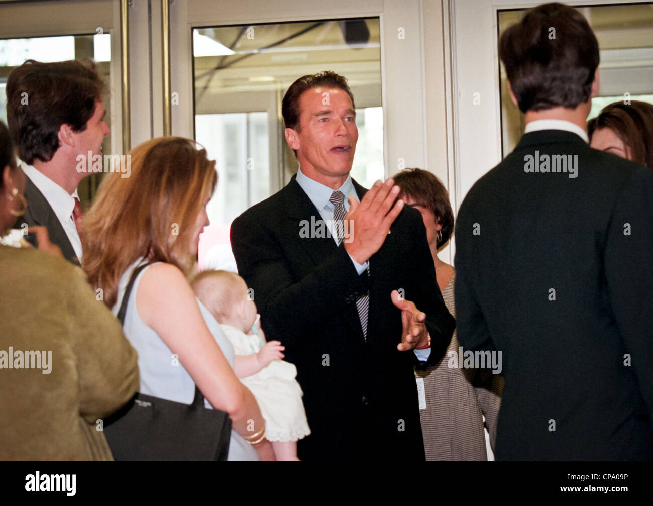 Actor Arnold Schwarzenegger jokes with his in-laws at the dedication of the Peace Corps headquarters September 15, 1998 in Washington, DC. Stock Photo