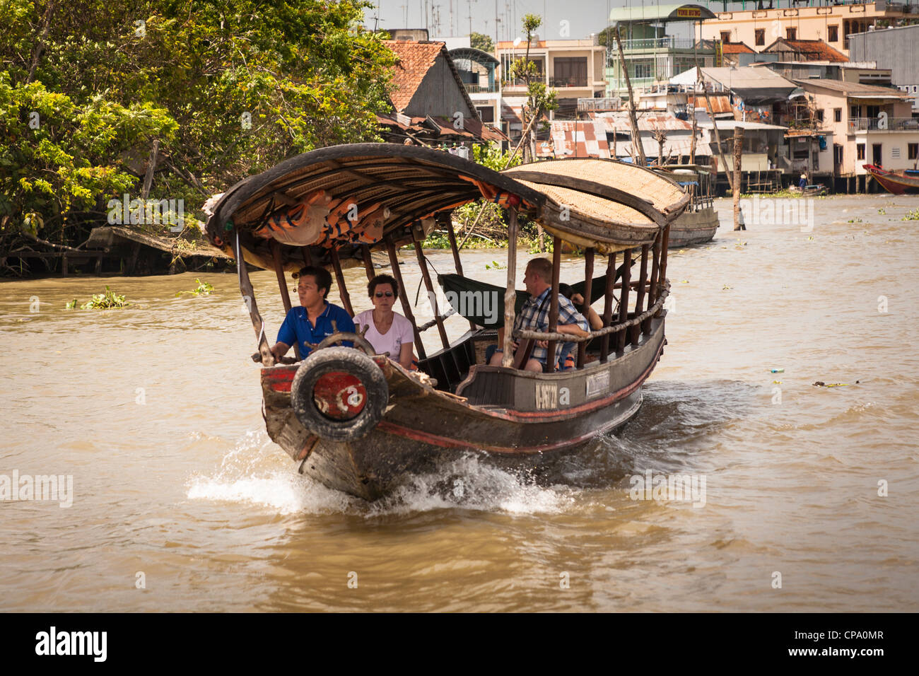 Tourists travelling on a small ferry boat, Cai Be, Mekong River Delta ...